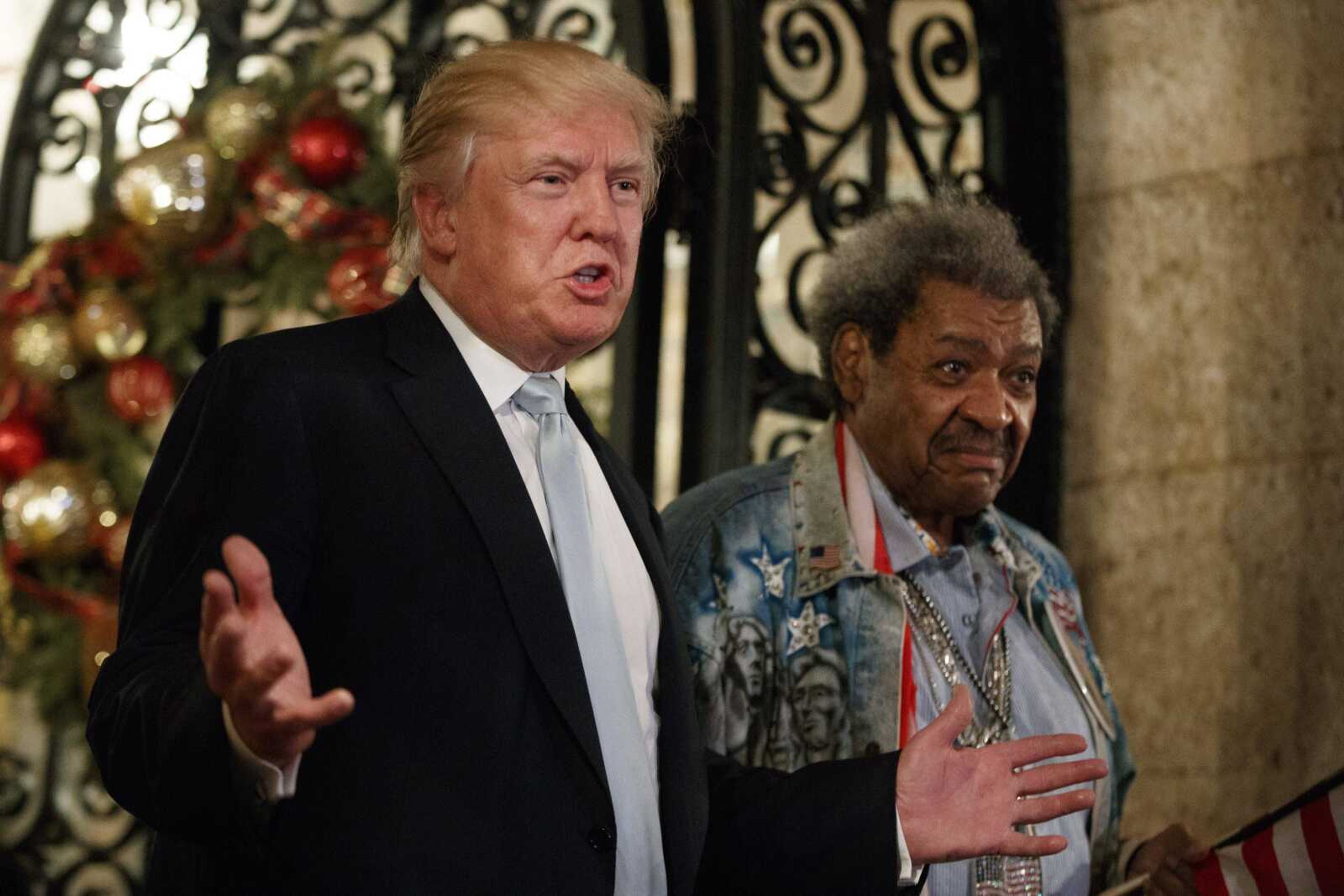 President-elect Donald Trump, left, stands with boxing promoter Don King as he speaks to reporters Wednesday at Mar-a-Lago, in Palm Beach, Florida.