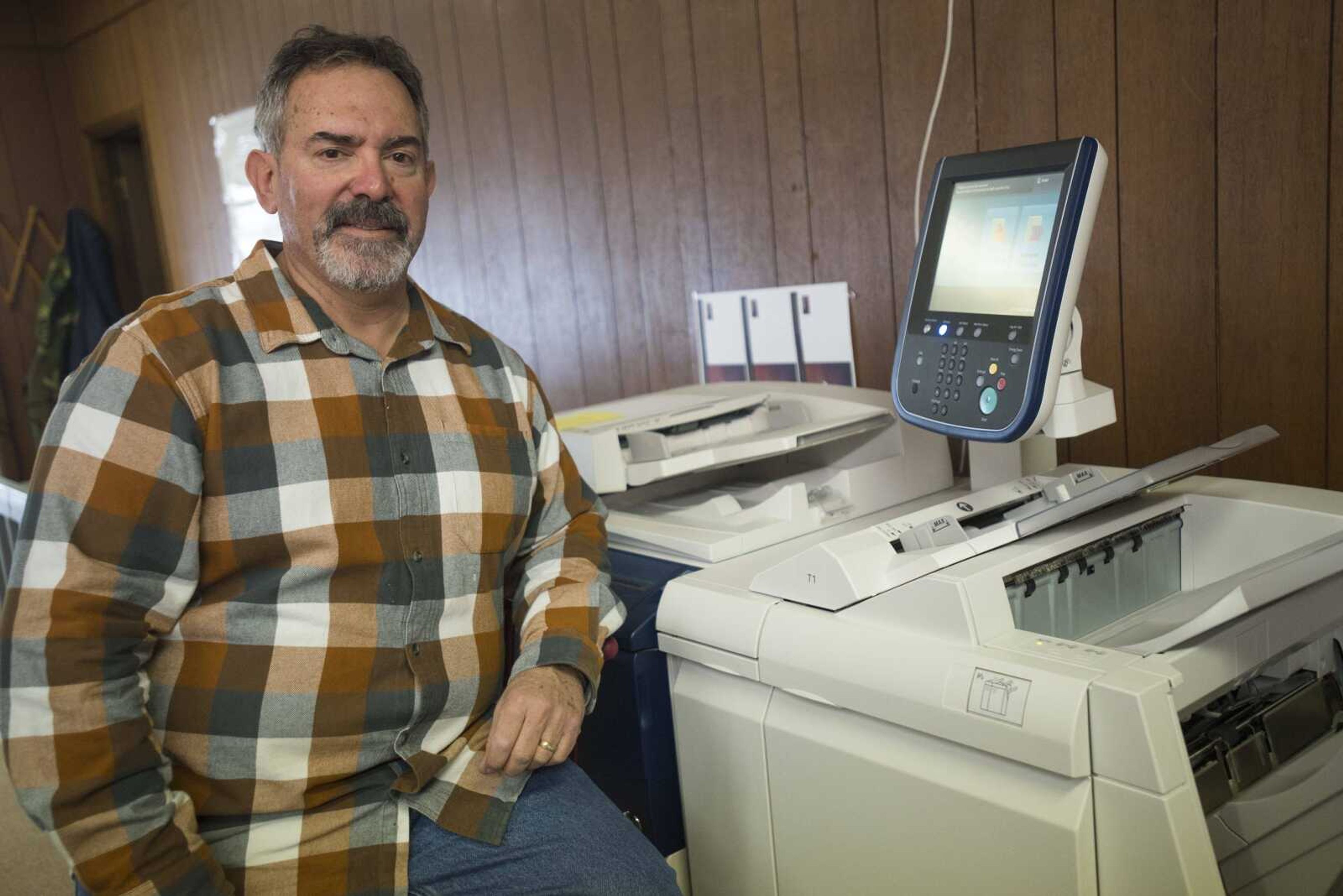 Steve Skelton stands next to a printing machine at Benchmark Graphics & Printing on Friday in Jackson.