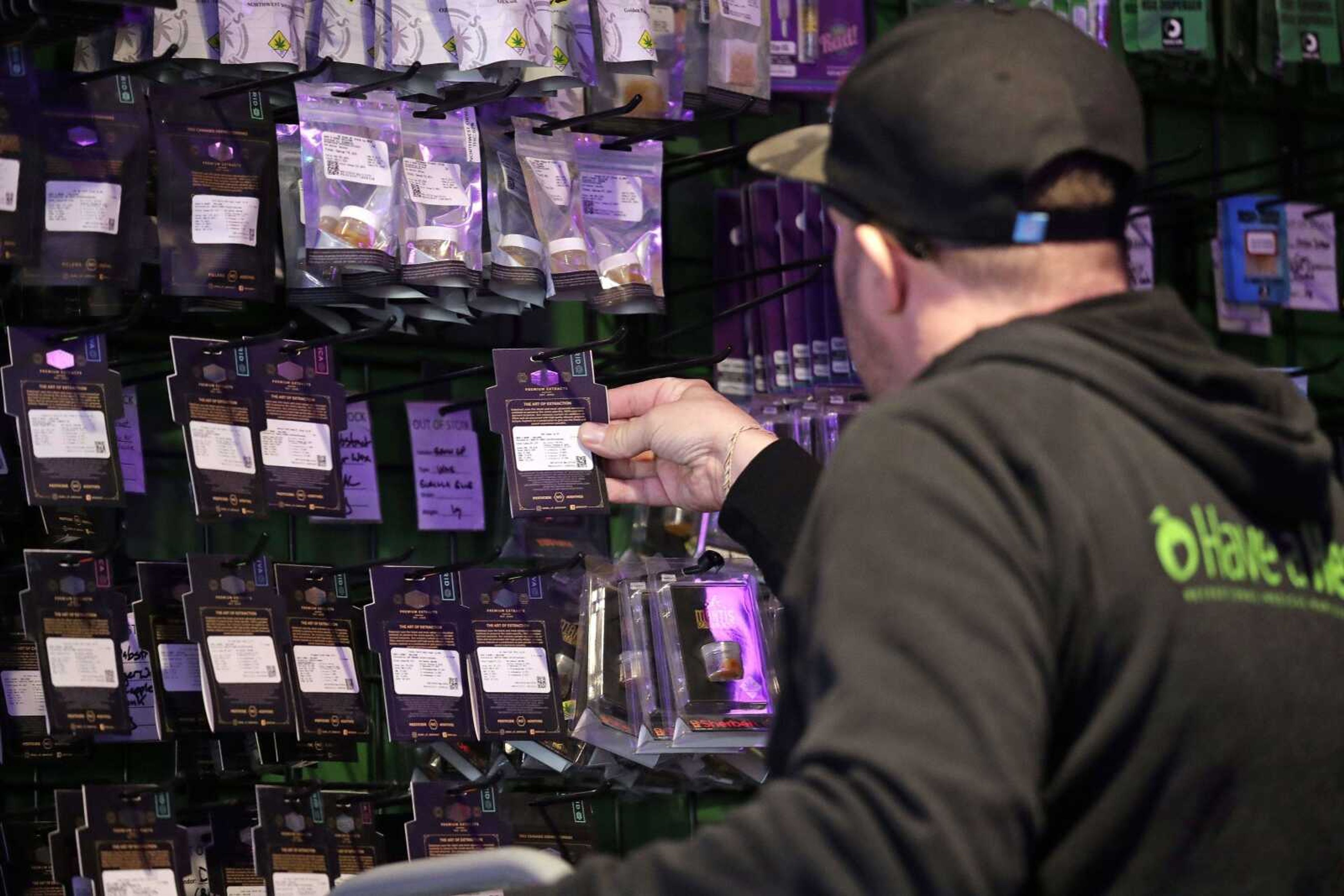 Store employee Adam Peckels retrieves products for customers Thursday at a marijuana shop in Seattle. When Washington and Colorado launched their pioneering marijuana industries in the face of U.S. government prohibition, they imposed strict rules in hopes of keeping the U.S. Justice Department at bay. Five years later, federal authorities have stayed away, but the industry says it has been stifled by over-regulation.