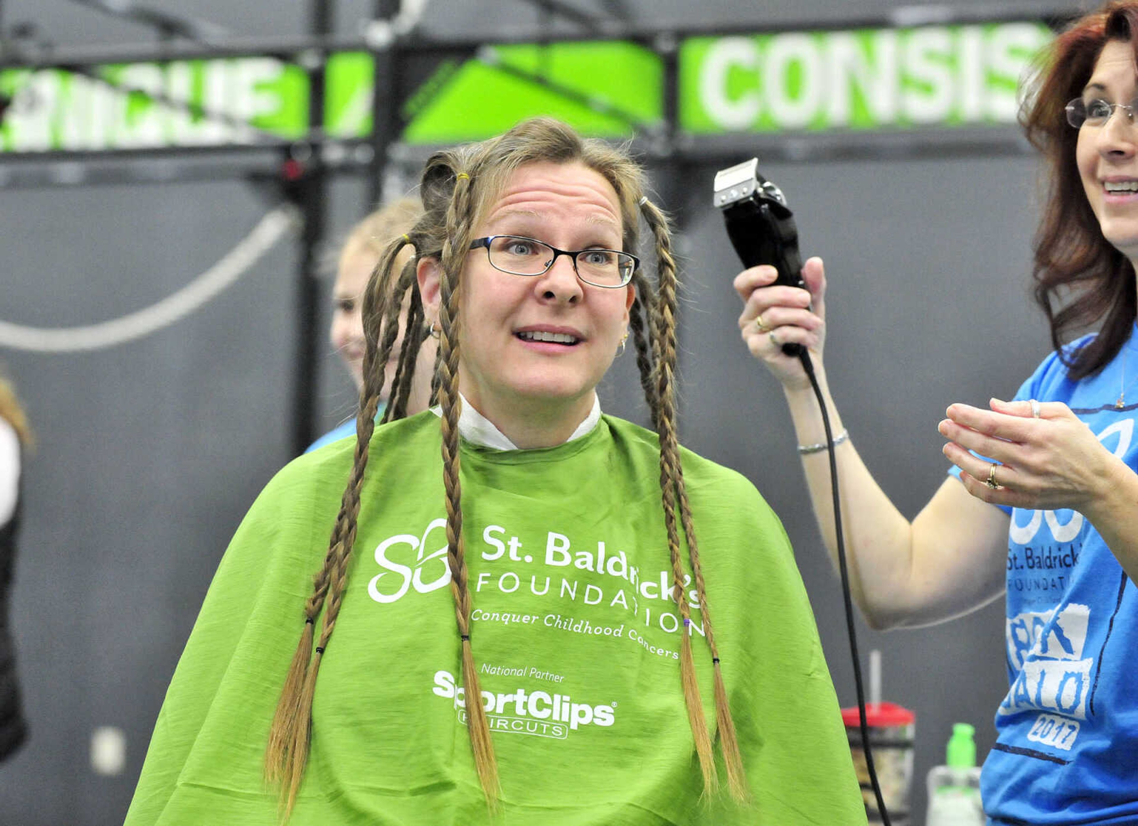 Jennifer Singleton looks to the crowd as April Whiteside begins to shave her head on Saturday, March 4, 2017, during the St. Baldrick's Foundation fundraiser at Old Orchard CrossFit in Jackson.