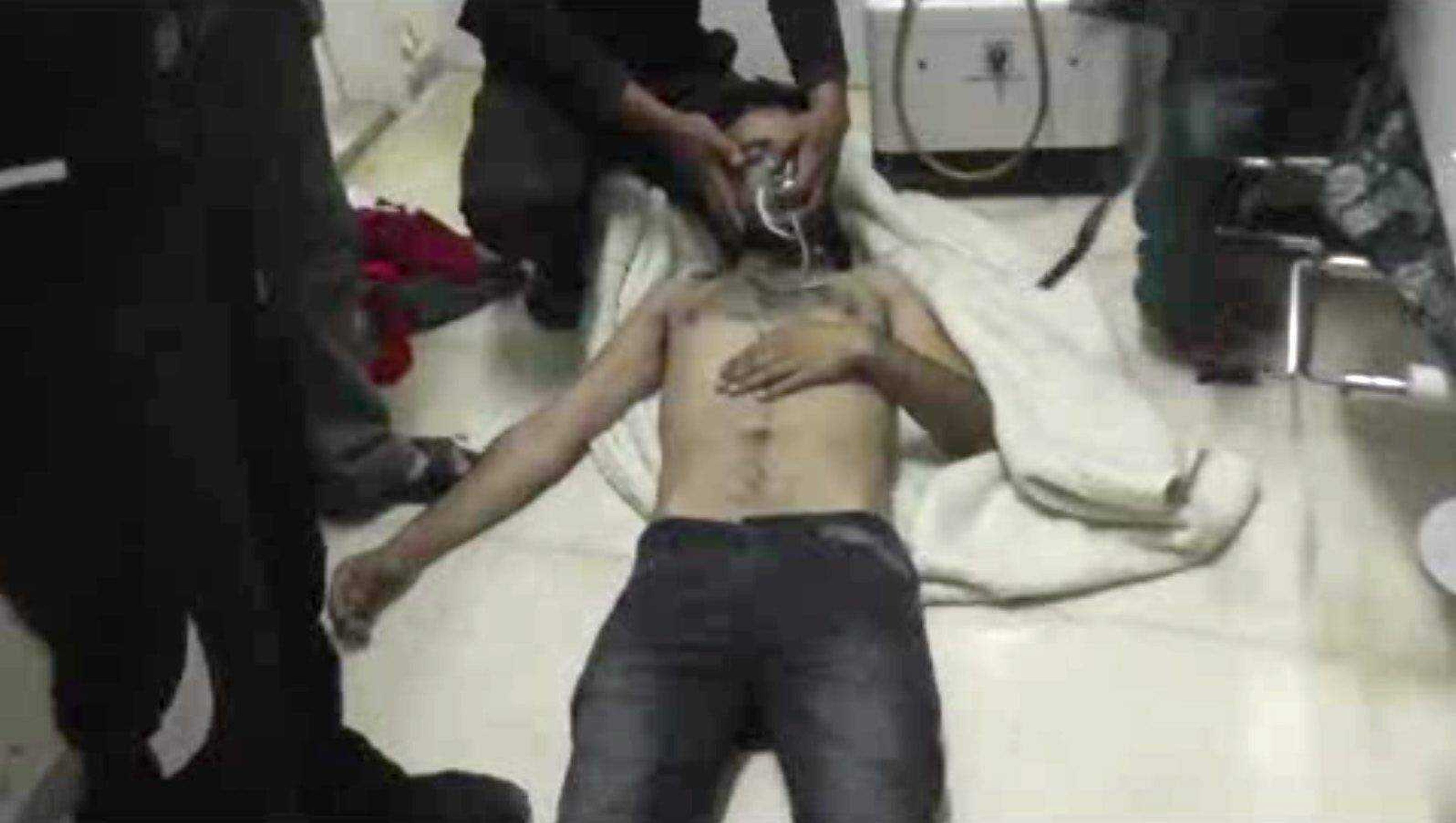 An image made from amateur video Friday shows a man lying on the floor with an oxygen mask at a hospital room in Kfar Zeita, Syria. Syrian government media and rebel forces said Saturday that poison gas had been used in the village, injuring scores of people while blaming each other for the attack. (Shams News Network ~ Associated Press)