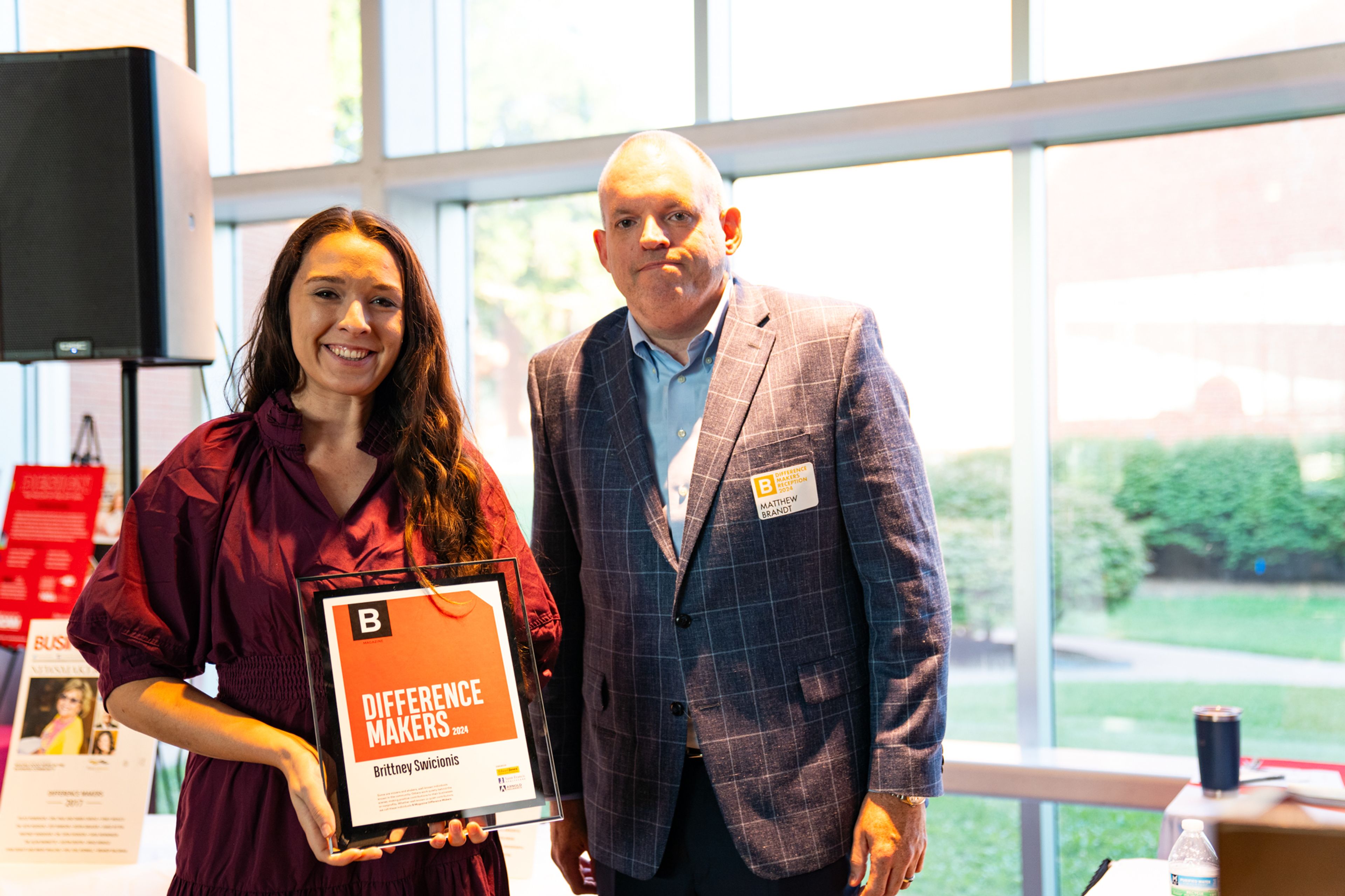 Brittney Swicionis receives a plaque from Saint Francis Healthcare System’s Matthew Brandt recognizing her as a 2024 Difference Maker at their reception at Southeast Missouri State University’s River Campus. The Difference Maker’s reception was presented by B Magazine on Thursday, Sept. 6.