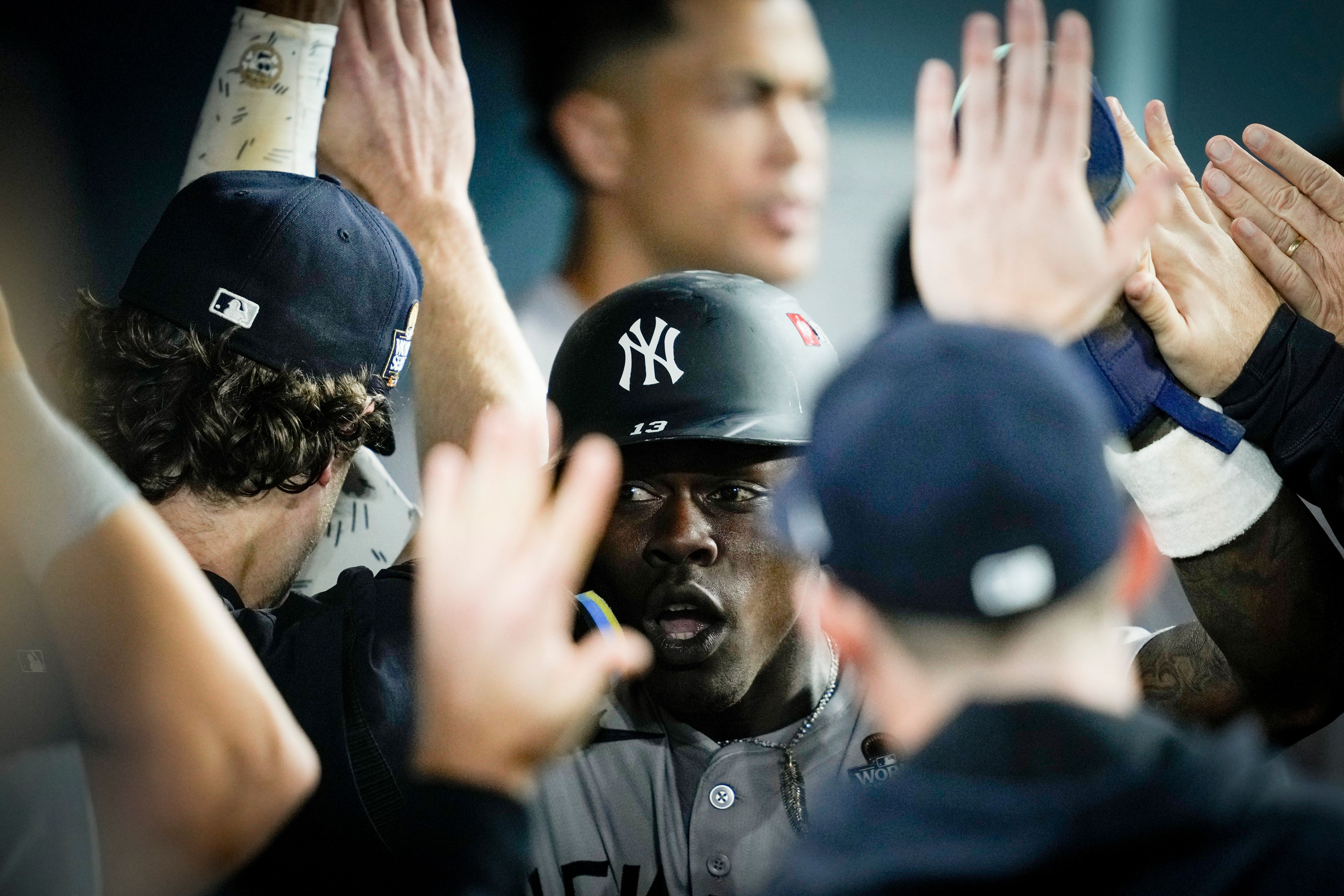 New York Yankees' Jazz Chisholm Jr. celebrates in the dugout after scoring on a fielders choice by Anthony Volpe against the Los Angeles Dodgers during the 10th inning in Game 1 of the baseball World Series, Friday, Oct. 25, 2024, in Los Angeles. (AP Photo/Ashley Landis)