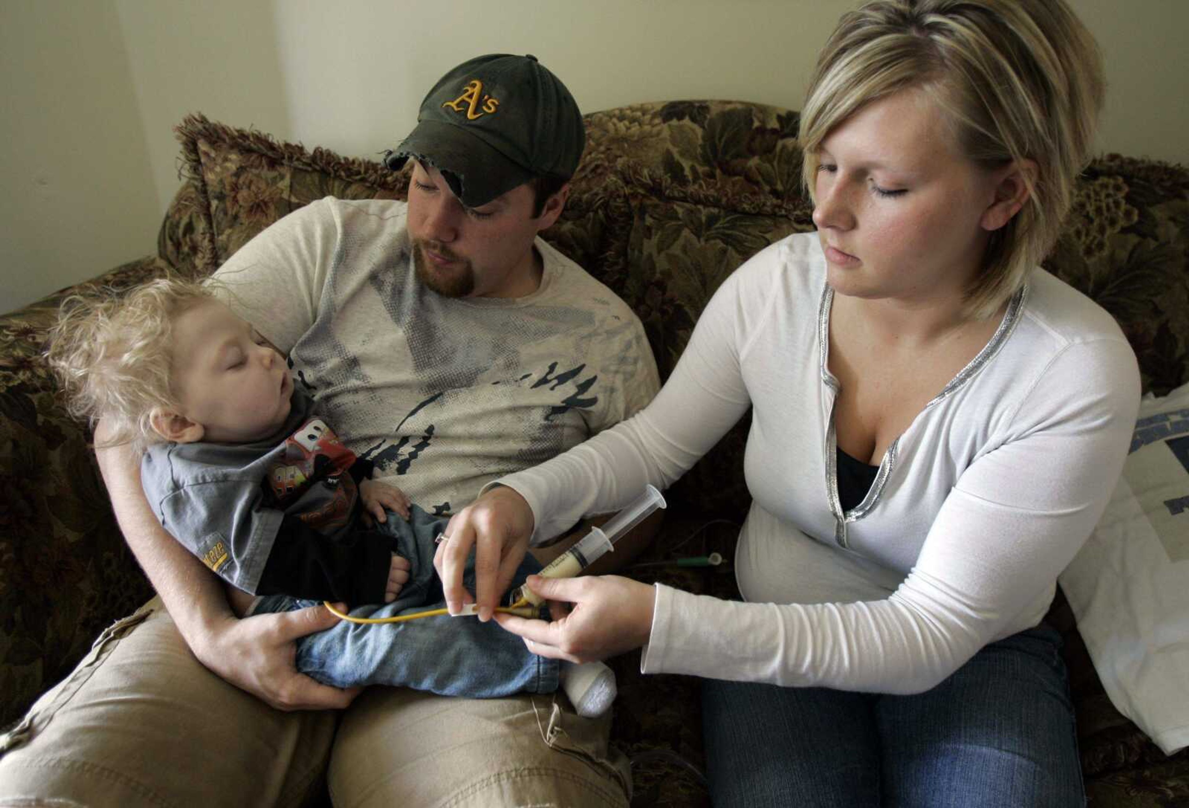 Dustin and Jessy Cunningham feed their son Brady through a tube in his stomach March 19 in Campbell, Mo. Brady, who was born a rare genetic condition called Krabbe disease, died Monday, just days before his first birthday. His parents are fighting for a new state law to get screening to identify Missouri newborns who have the disease. (Jeff Roberson ~ Associated Press)