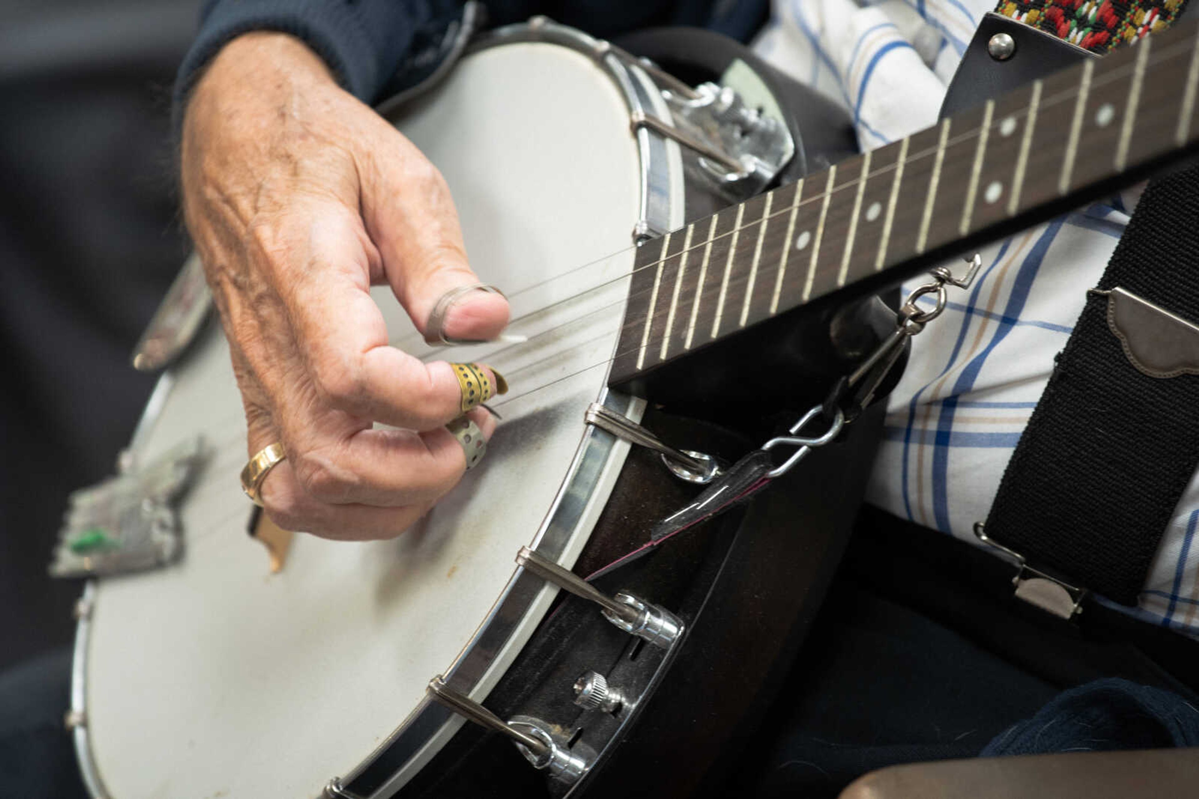 Dean Percival plays banjo at Hombre Barber Shop in Cape Girardeau during a weekly jam session. The music circle started taking place in 2006.