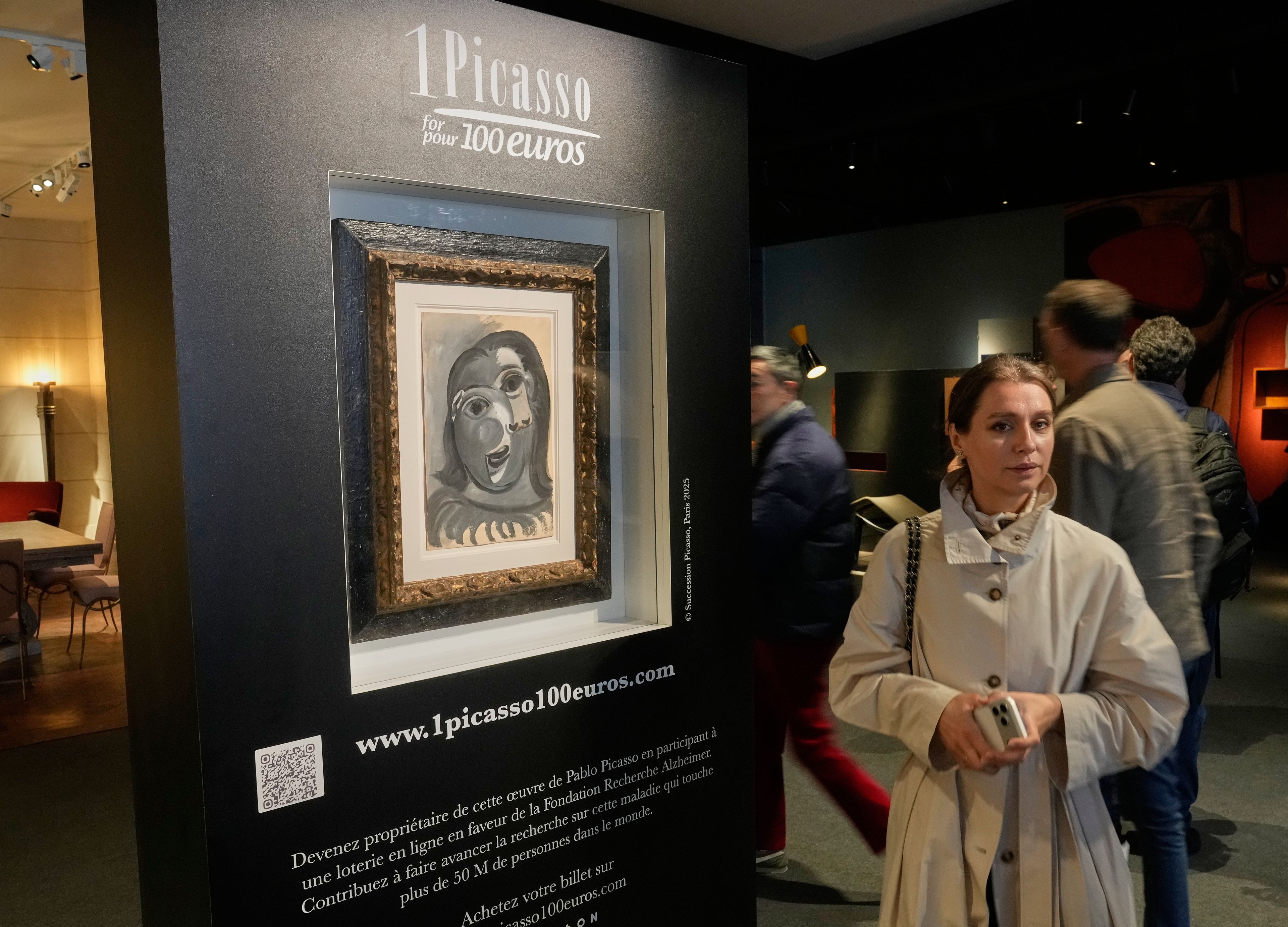 People walk past the Head of a Woman by Pablo Picasso, painted in 1941, in Paris, Friday, April 10, 2026, ahead of a lottery in which the painting is being raffled off to raise money for Alzheimer’s research. (AP Photo/Michel Euler)