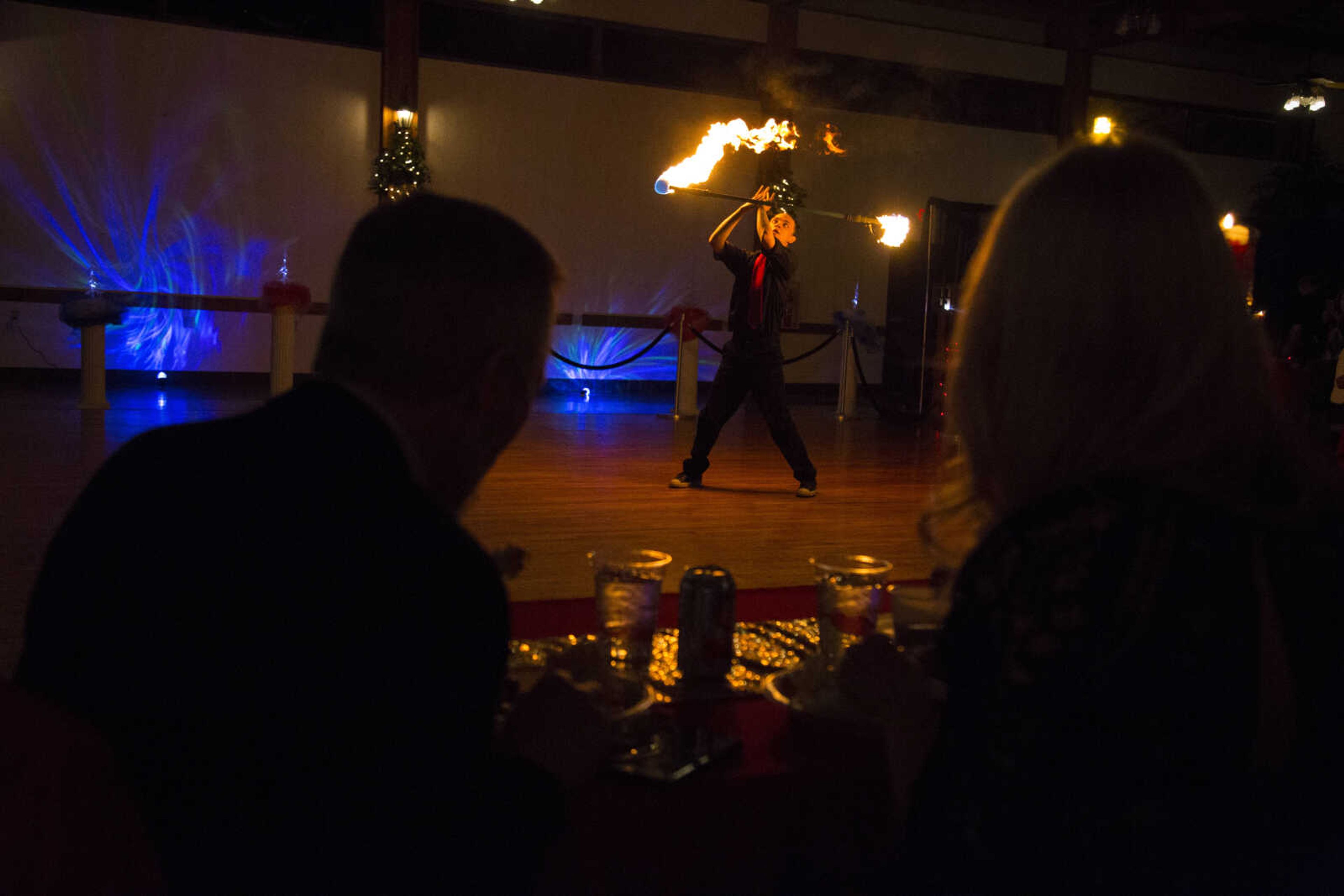 A couple eats their meal while Ezra Caldwell dances with fire Saturday, Feb. 3, 2018, during the Fire and Ice Gala at Bavarian Halle in Jackson.