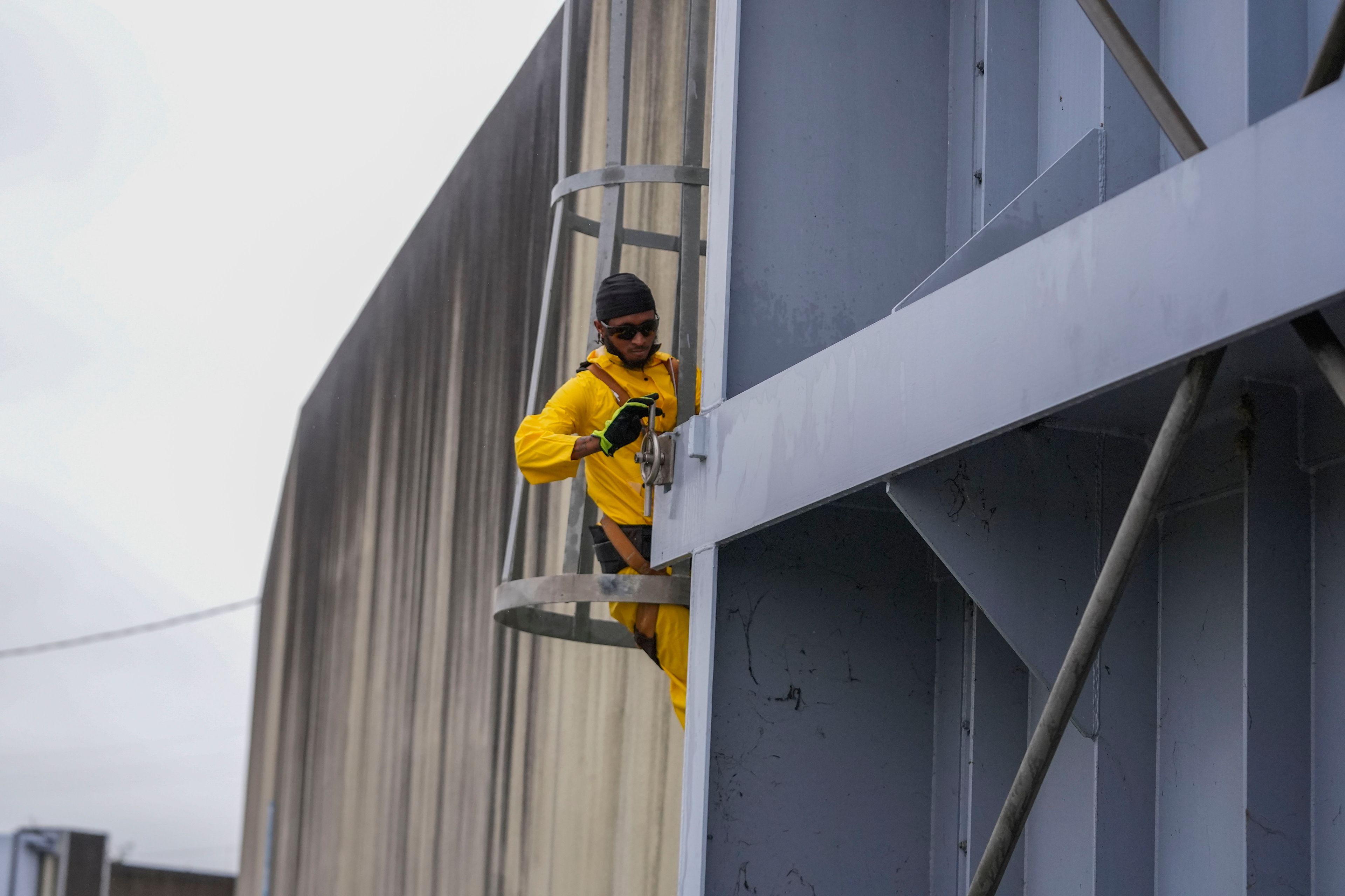 A worker from the Southeast Louisiana Flood Protection Authority-West tightens turnbuckles as they close floodgates along the Harvey Canal, just outside the New Orleans city limits, in anticipation of Tropical Storm Francine, in Harvey, La., Tuesday, Sept. 10, 2024. (AP Photo/Gerald Herbert)