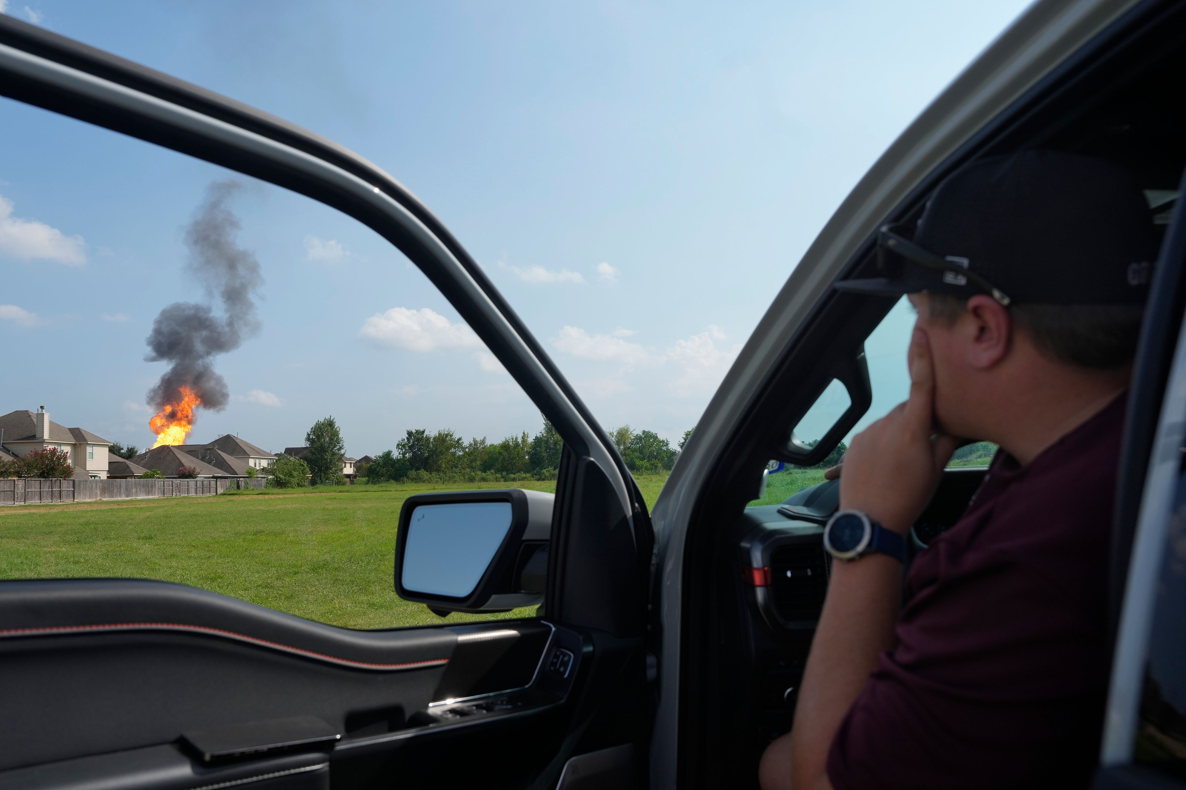 A Clear Lake man watches the pipeline fire burning in La Porte, Texas, as he gives a ride to his friend who is a resident on E. Meadow Drive, Monday, Sept. 16, 2024, in Deer Park, Texas. (Yi-Chin Lee/Houston Chronicle via AP)