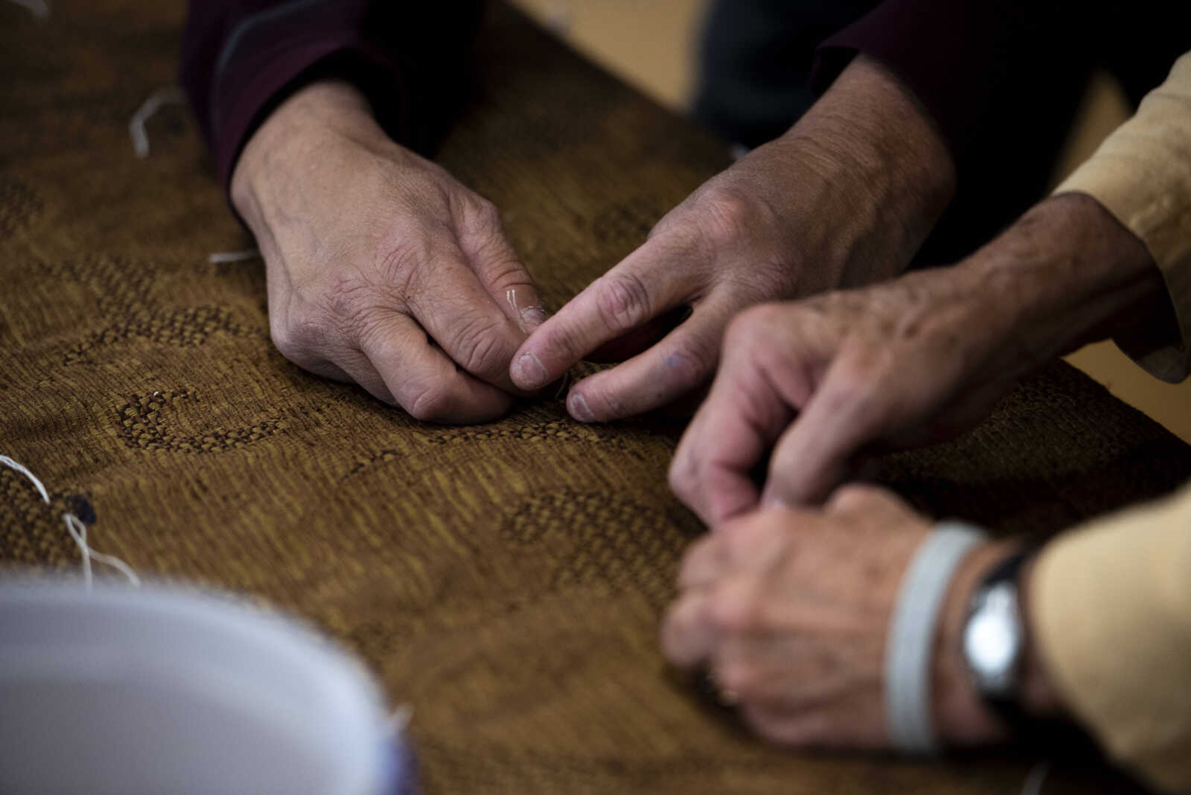 James Saucier, left, and Diane Essner, right, tack a quilted bed roll during the Ugly Quilt Weekend at St. Vincent de Paul Parish Sunday, Oct. 28, 2018, in Cape Girardeau.