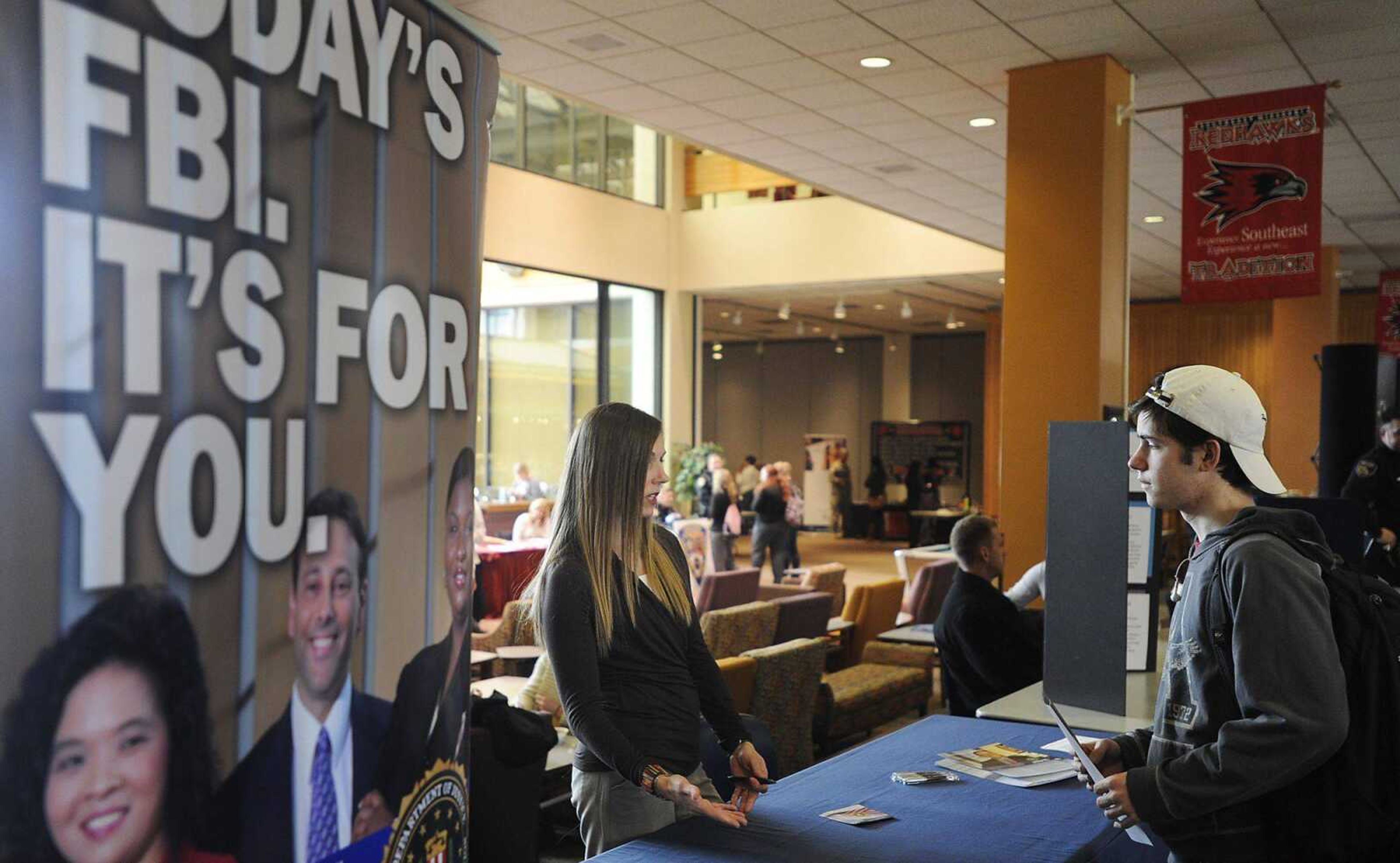 Southeast Missouri State University freshman Joel Cooper talks with FBI Special Agent Karyn Feeny during a law enforcement career fair held as part of the 38th annual Criminal Justice Day Wednesday, March 6, at the University Center. Cooper said that while he currently plans to attend medical school after graduation he considers a career with the FBI to be an option he might be interested in. (ADAM VOGLER)