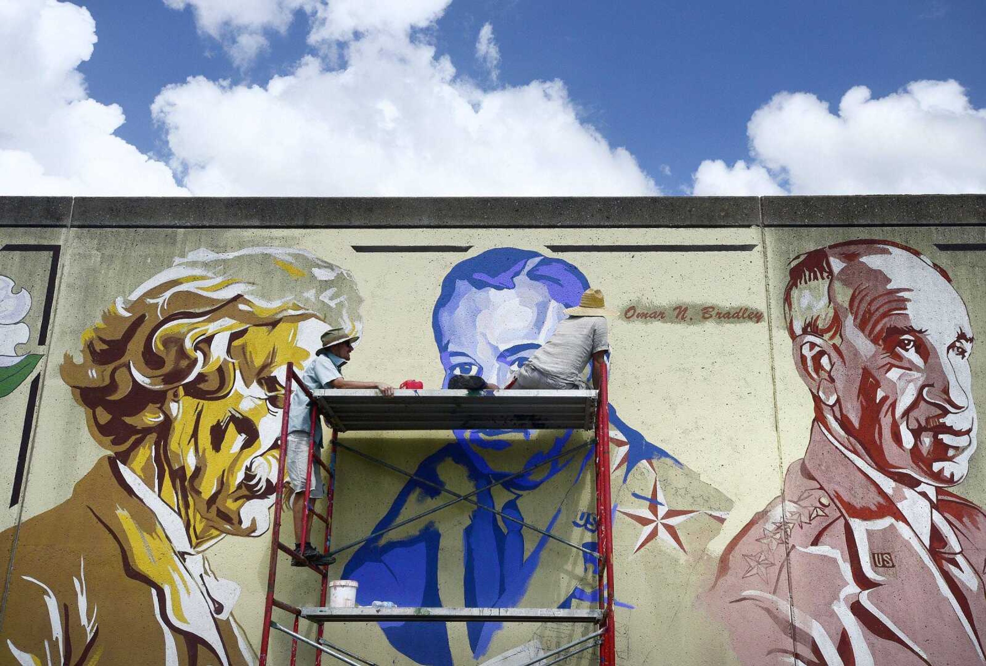 Jess Wells, left, and Craig Thomas work on a mural Thursday of the late Gen. Seth McKee on the Cape Girardeau downtown Wall of Fame.