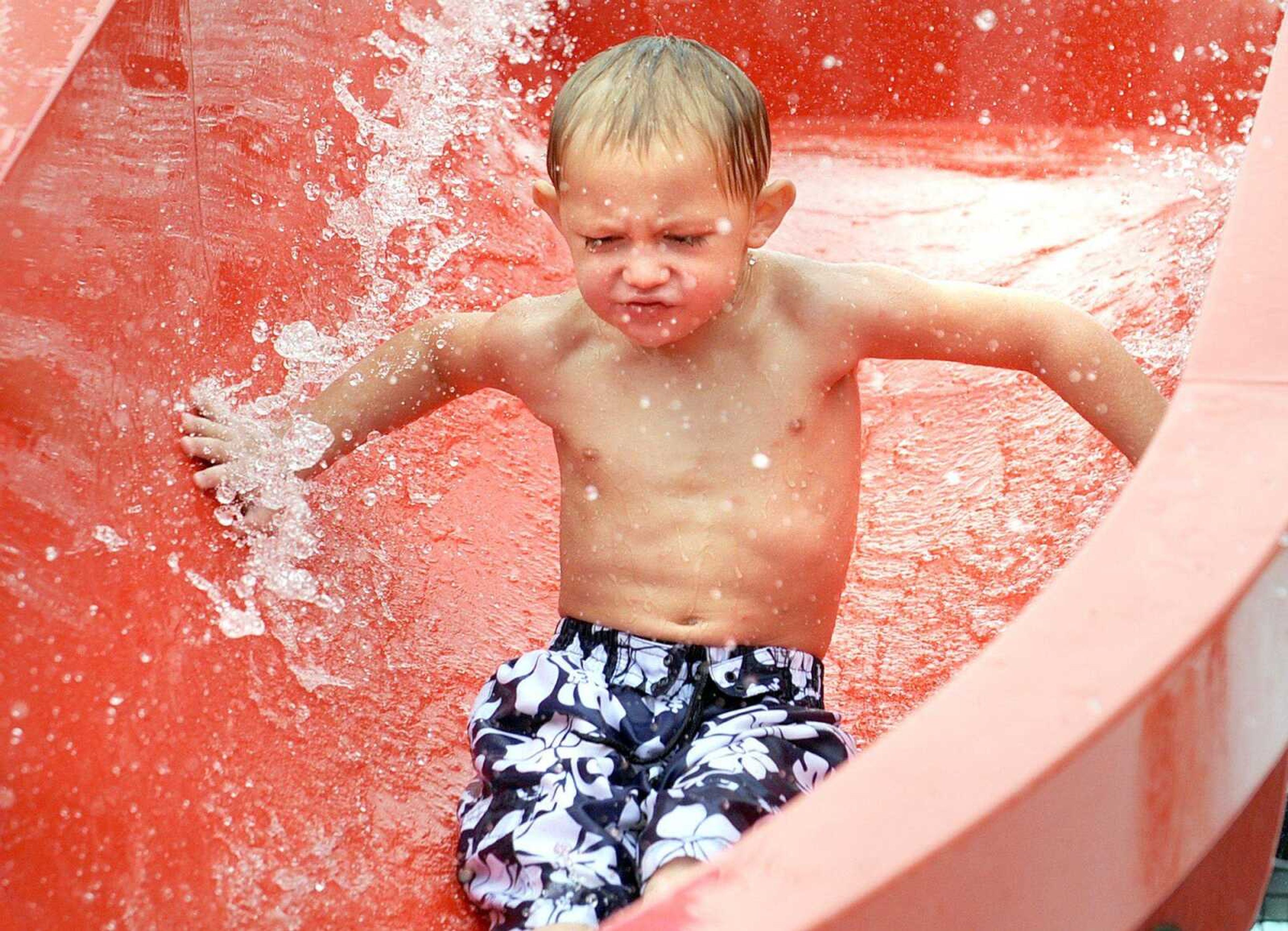 Grayson Rawson, 3, of Oran, Mo., keeps his eyes shut as he goes down the water slide Monday, Sept. 3, 2012, in Cape Girardeau. Monday was the last day of the season for the water park. (Laura Simon)