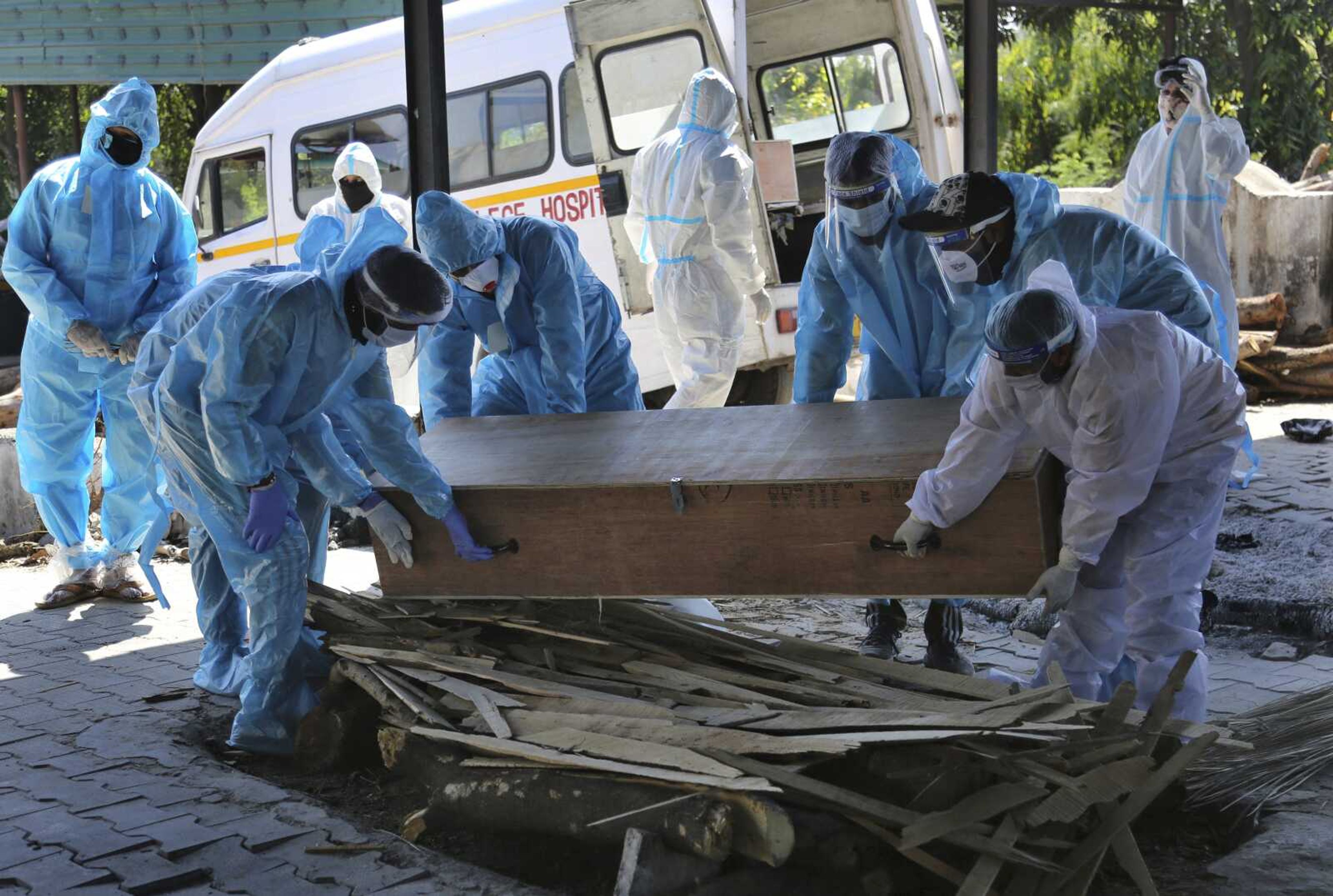 Health workers and relatives carry the body of a COVID-19 victim for cremation April 25, 2021, in Jammu, India. The World Health Organization is estimating nearly 15 million people were killed either by the coronavirus or by its impact on overwhelmed health systems in the past two years. That is more than double its official death toll.