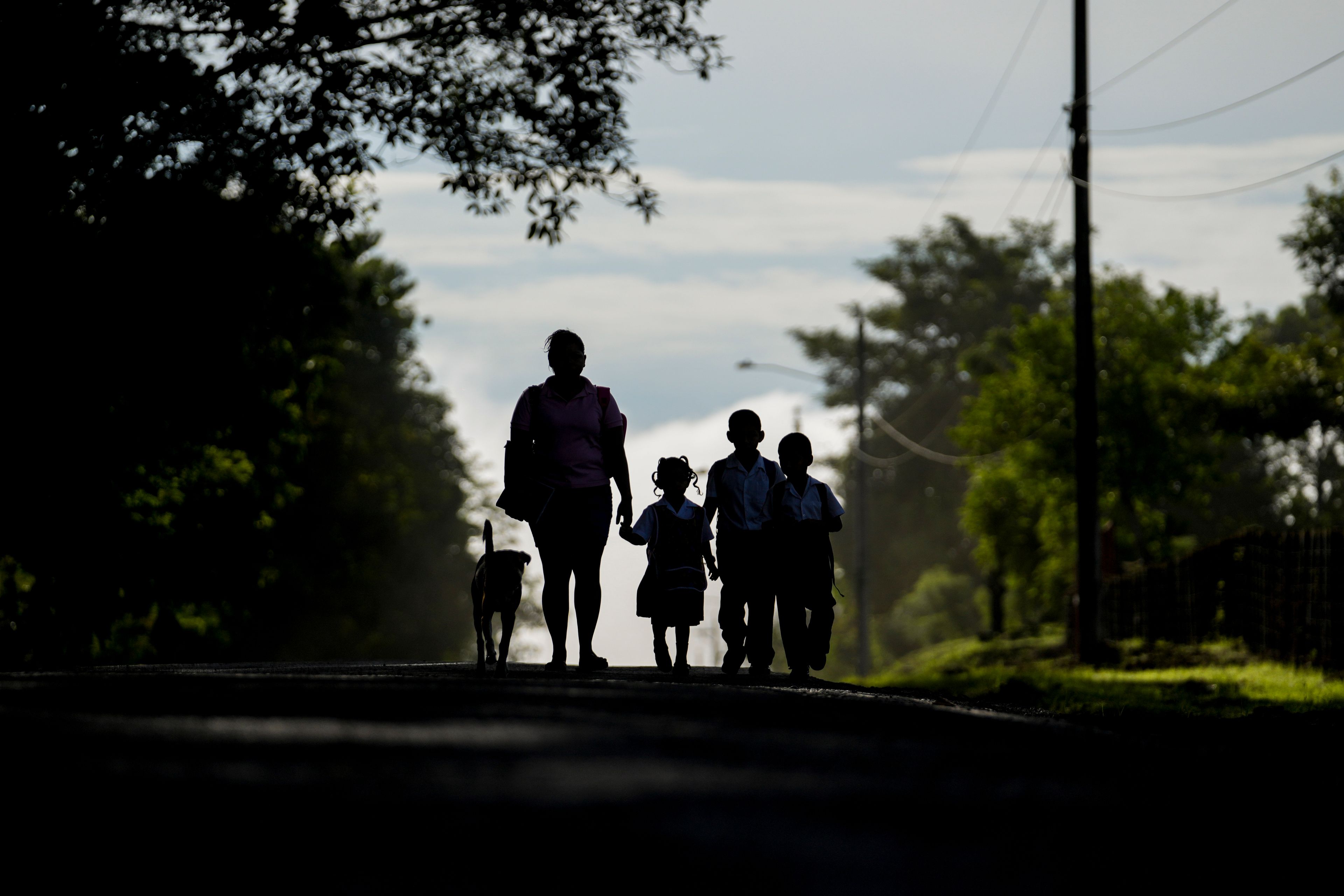 A woman walks with her children through the street in Piriati, Panama, Sept. 25, 2024. (AP Photo/Matias Delacroix)