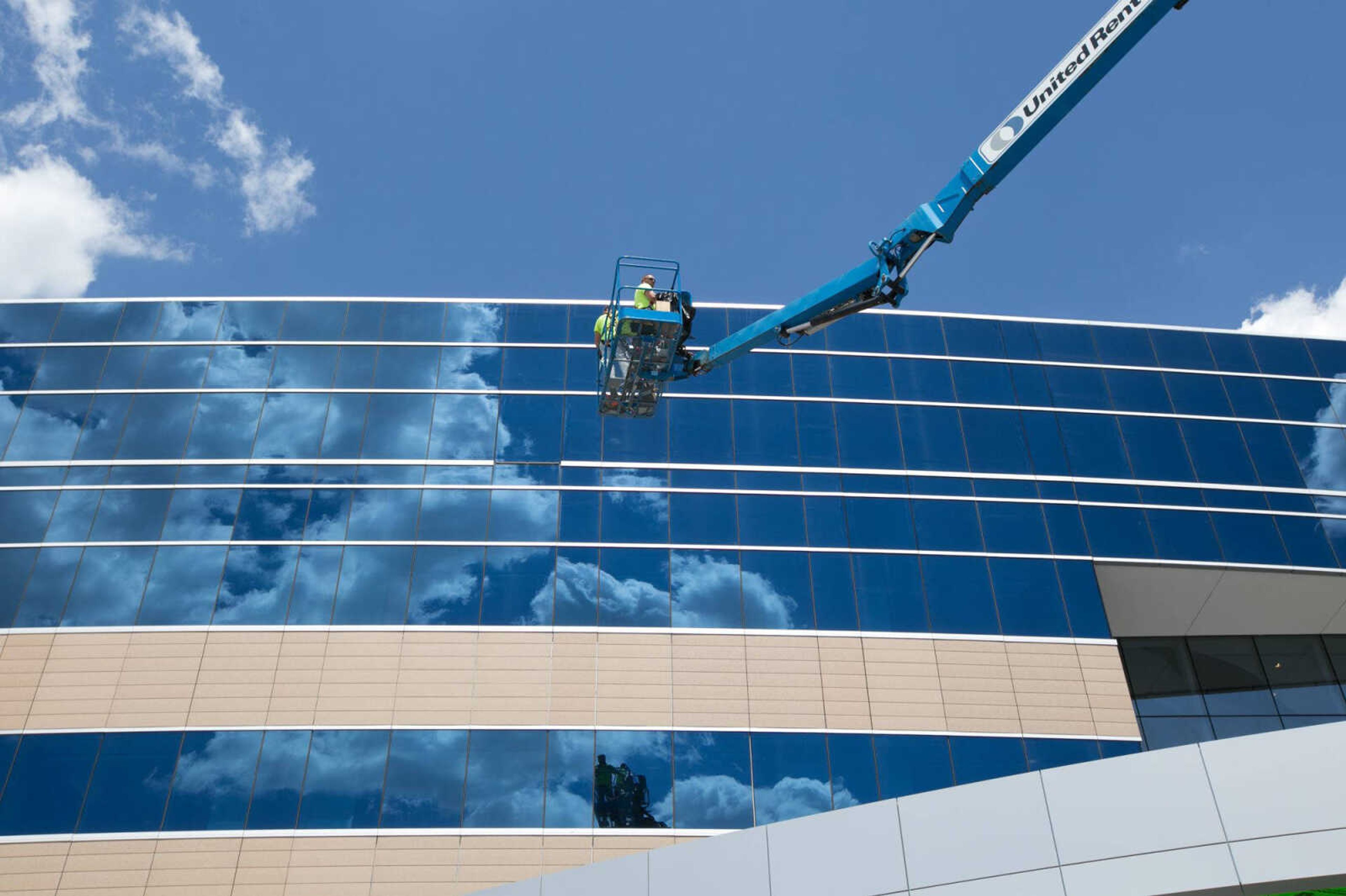 Brad McCord and Josh Abrantes ride a lift to seal windows on the new expansion of Saint Francis Medical Center on April 29. (Glenn Landberg)