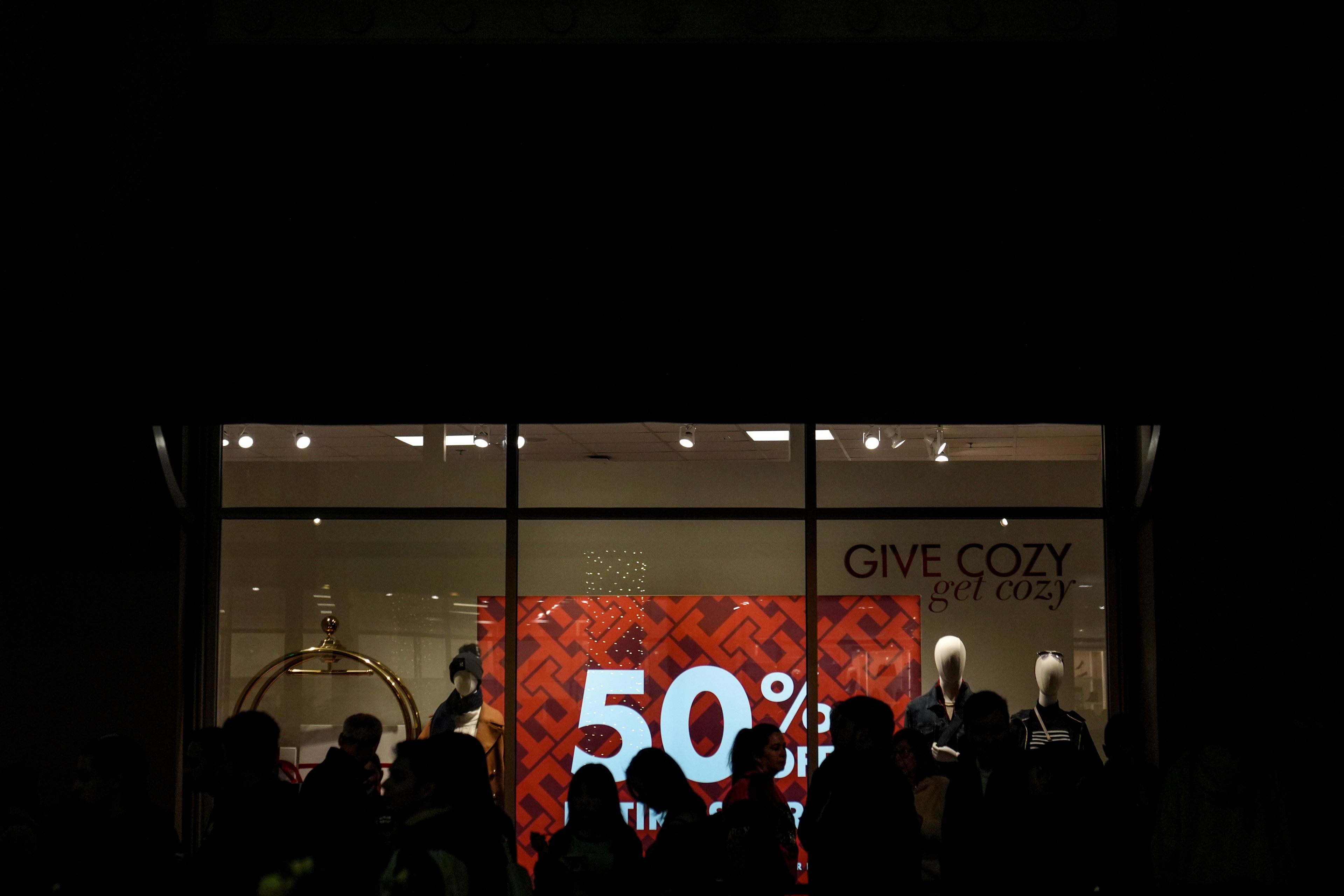 Early Black Friday shoppers are silhouetted as they wait in line to enter a store at Citadel Outlets in Commerce, Calif., Thursday, Nov. 28, 2024. (AP Photo/Jae C. Hong)