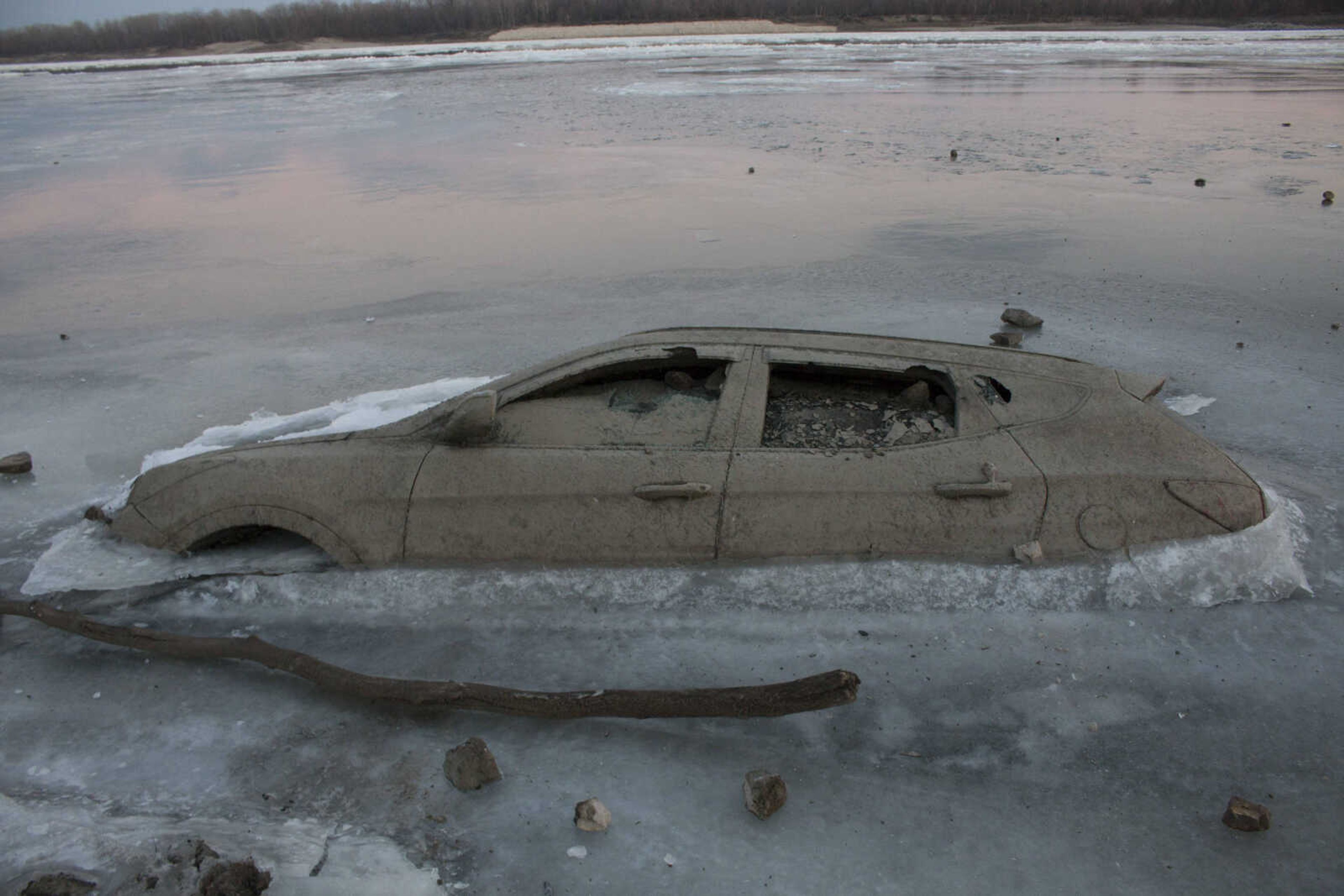 A sunken vehicle protrudes through a frozen section of the Mississippi River on Wednesday in Cape Girardeau.