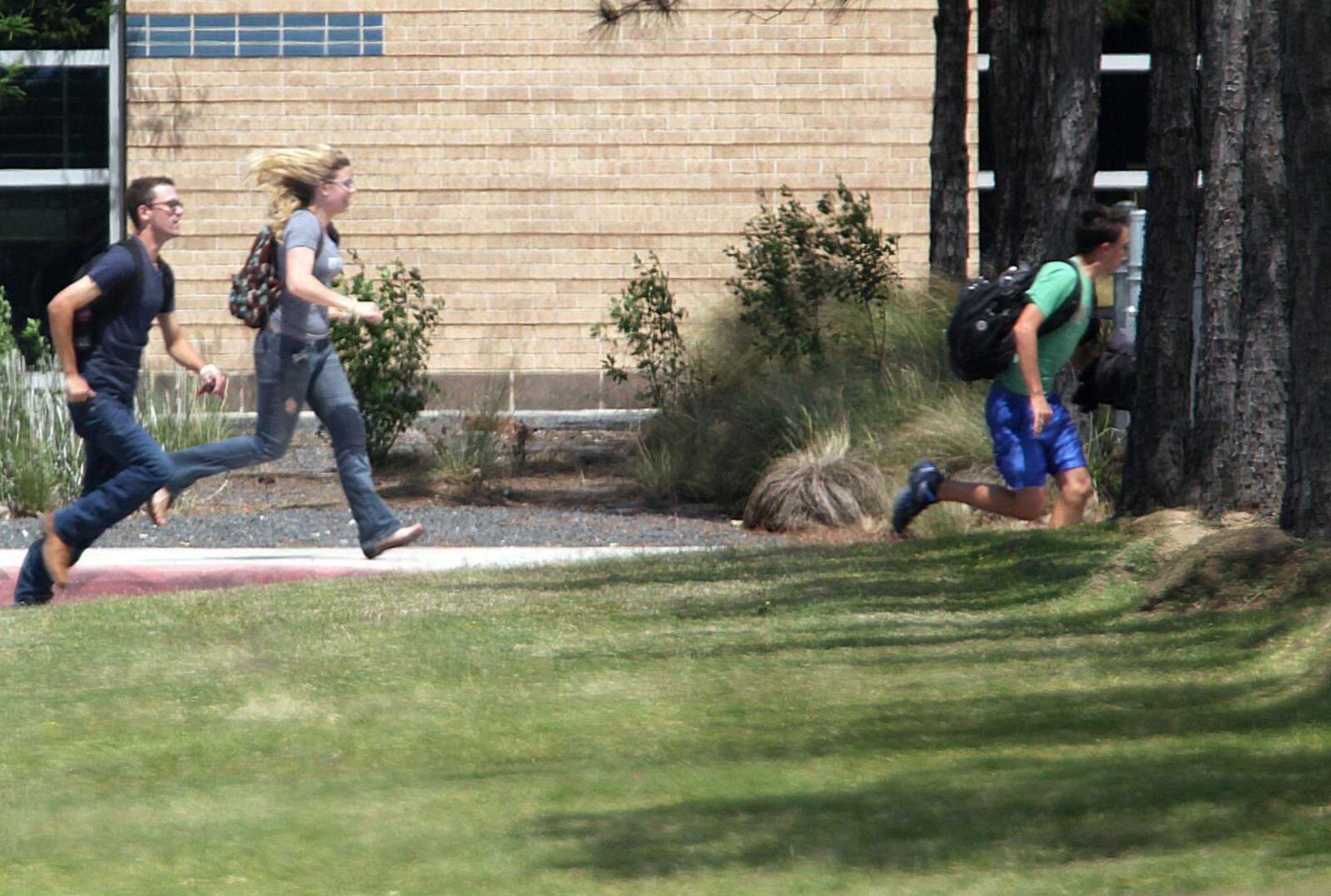 Students run from the Lone Star College&#8217;s Cy-Fair campus Tuesday in Cypress, Texas, where a student went on a building-to-building stabbing attack. (James Nielsen ~ Houston Chronicle, Associated Press)