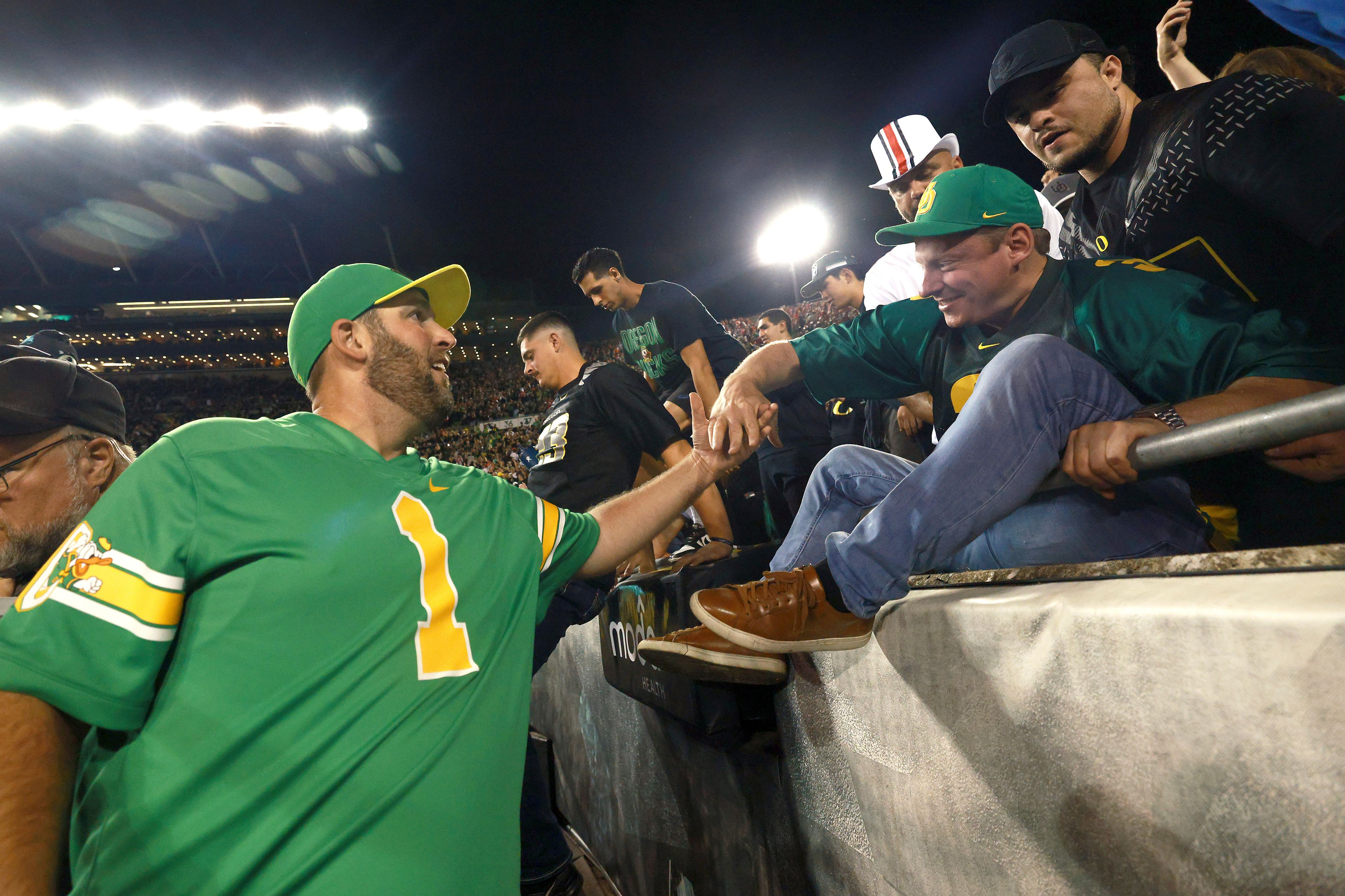 Oregon fans storm the field after Oregon's win over Ohio State in an NCAA college football game, Saturday, Oct. 12, 2024, in Eugene, Ore. (AP Photo/Lydia Ely)