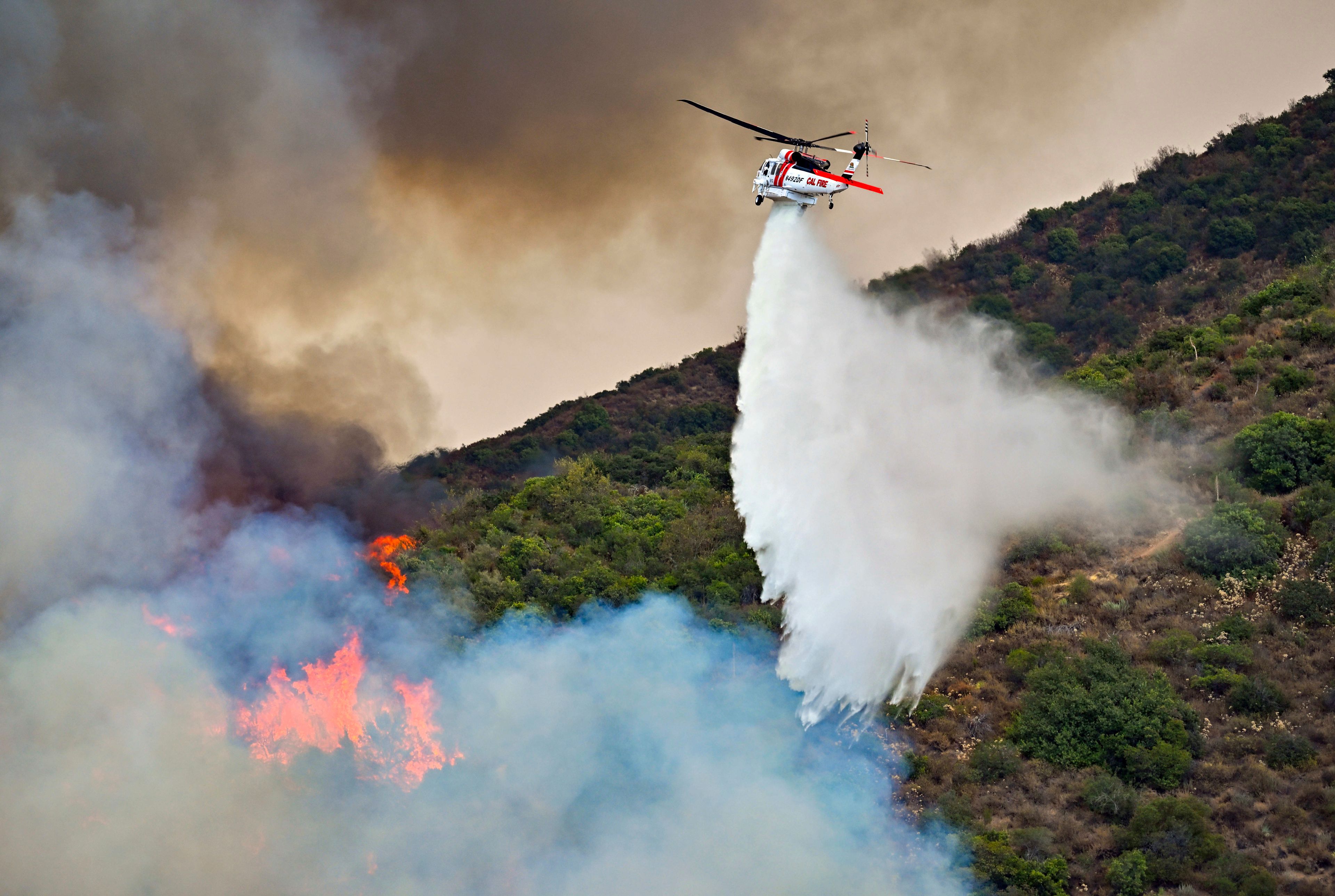 Firefighters battle the Airport Fire along Trabuco Creek Road in Trabuco Canyon, Calif., on Monday, Sept. 9, 2024. (Jeff Gritchen/The Orange County Register via AP)