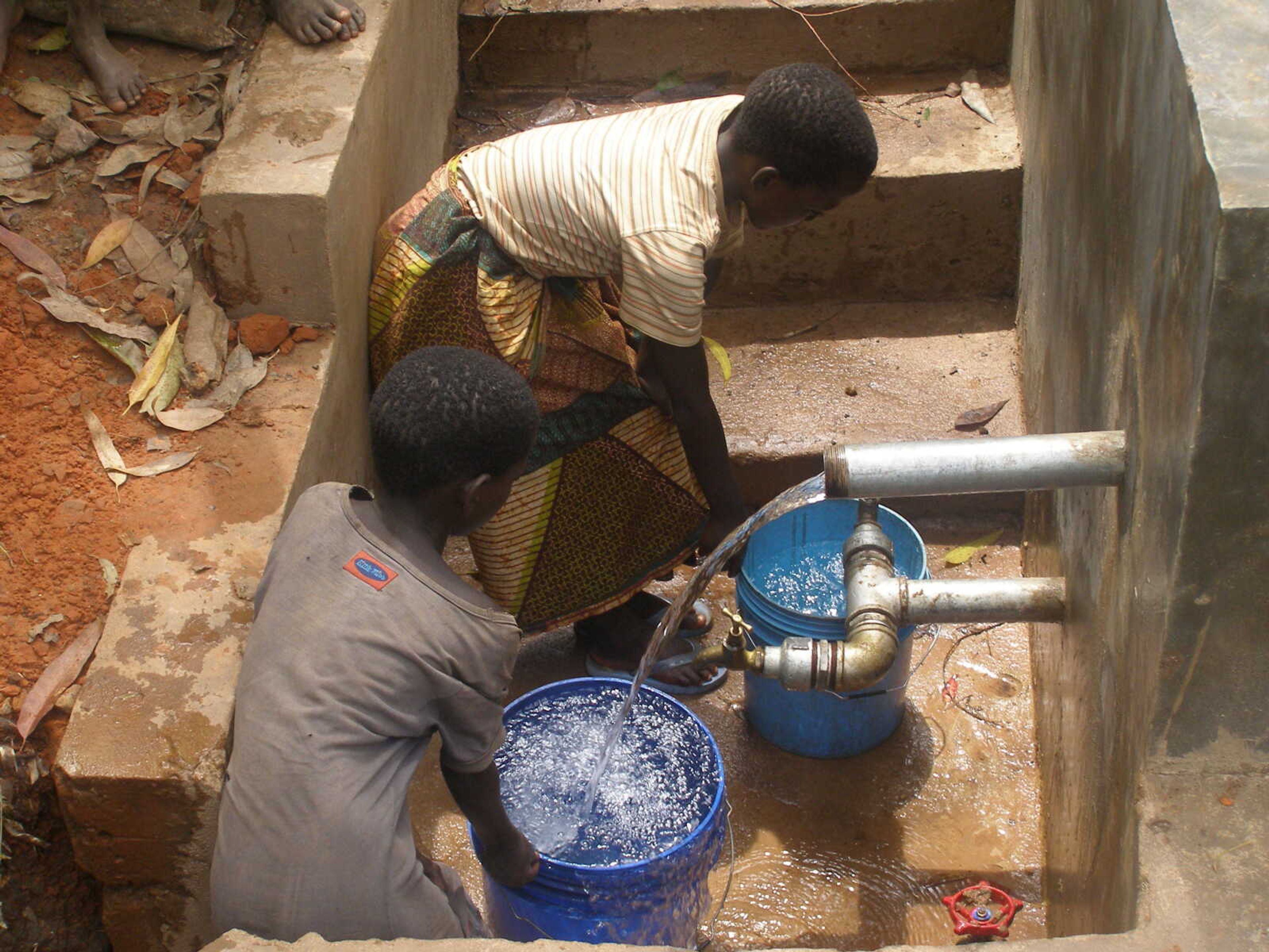 (Submitted photo)
Two people get clean water at a Five for Water project in Tanzania.