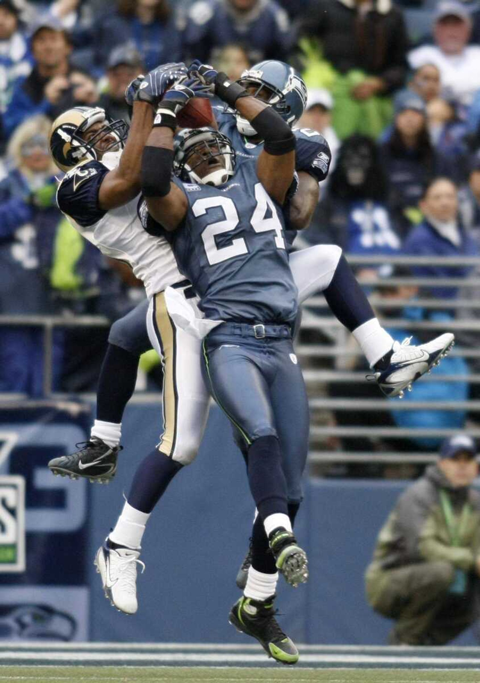 Seattle Seahawks safety Deon Grant (24) intercepts a pass from St. Louis Rams quarterback Marc Bulger intended for wide receiver Travis Taylor, left, with Marcus Trufant also defending behind, with less than two minuets left in their football game in Seattle, Sunday, Oct. 21, 2007. The Seahawks won 33-6. (AP Photo/John Froschauer)