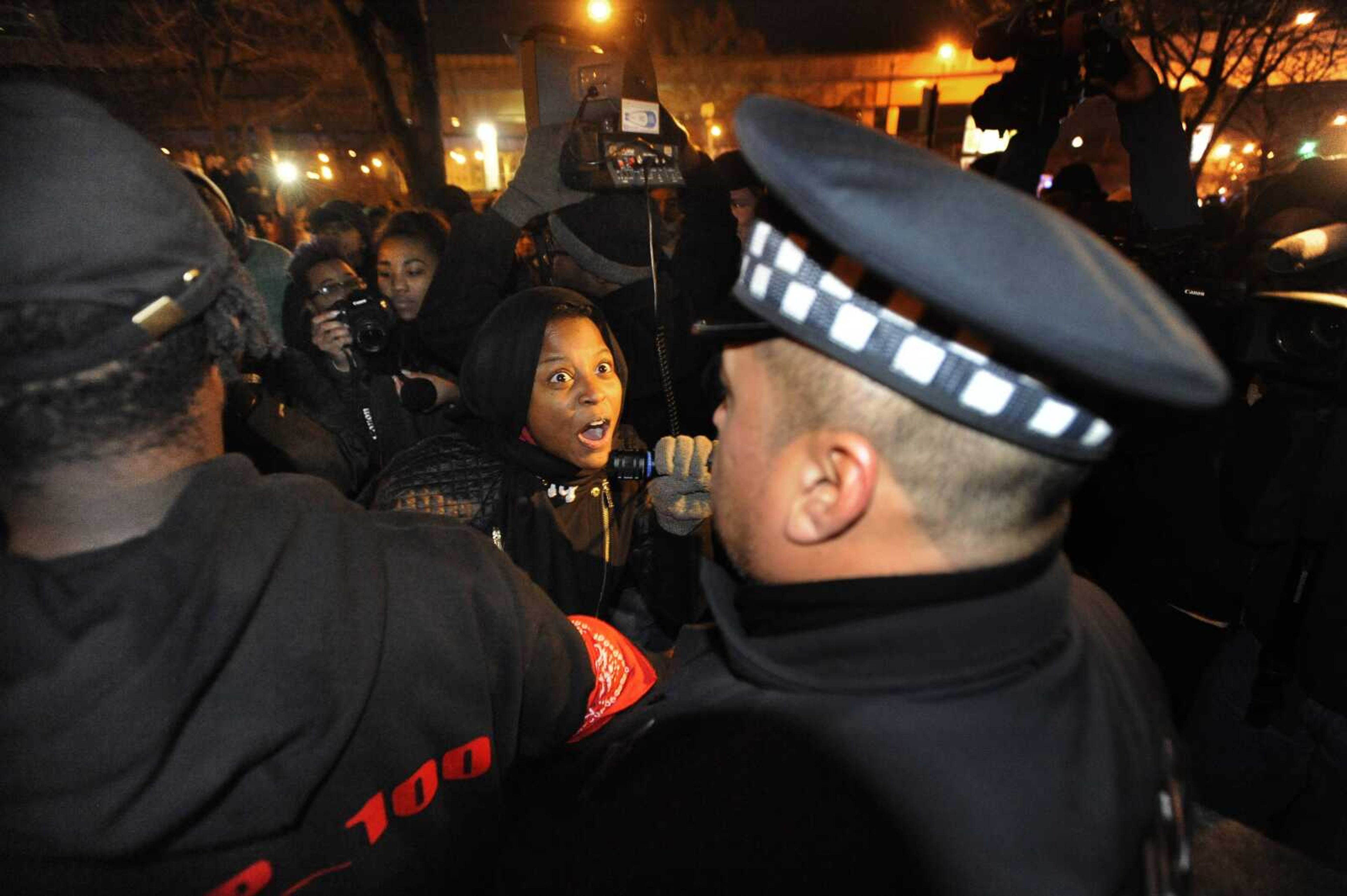 A protester yells at Chicago police officers outside the District 1 central headquarters at 17th and State streets Tuesday in Chicago during a protest for 17-year-old Laquan McDonald, who was fatally shot and killed in October 2014. Chicago police Officer Jason Van Dyke was charged Tuesday with first-degree murder in the killing. (Paul Beaty ~ Associated Press)