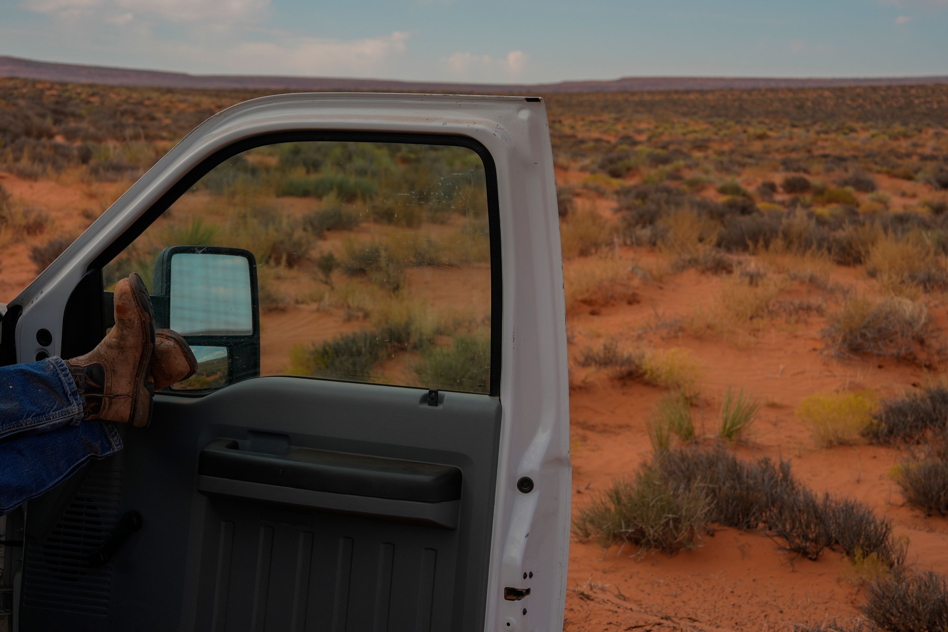 Robert Black, a project leader with the Navajo Tribal Utility Authority, relaxes in a truck during a lunch break while installing power line poles at a home, Tuesday, Oct. 8, 2024, on the Navajo Nation in Halchita, Utah. (AP Photo/Joshua A. Bickel)