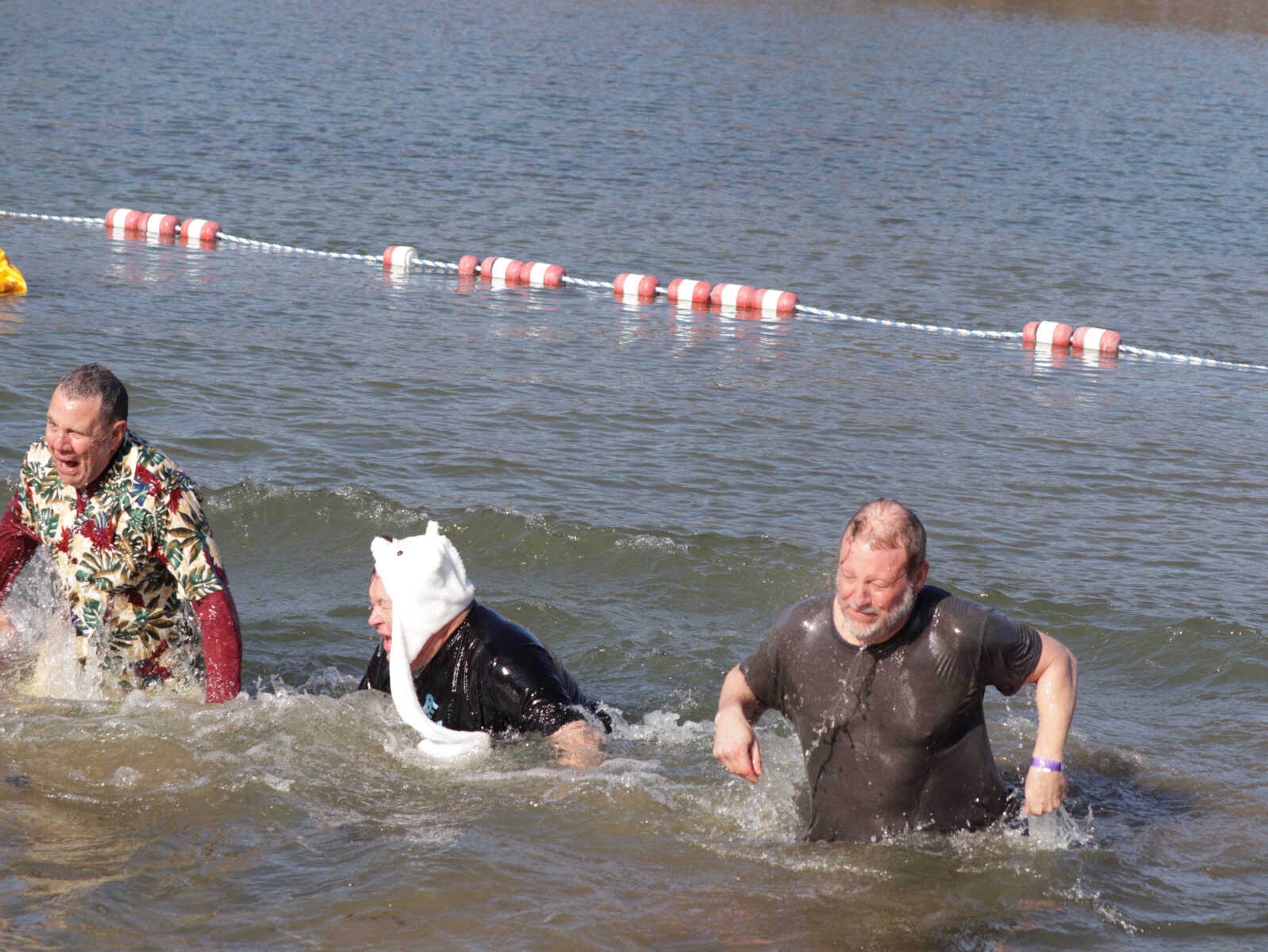 Members of the Cape Noon Optimist Club struggle to get out of the cold water Saturday at the Polar Plunge.