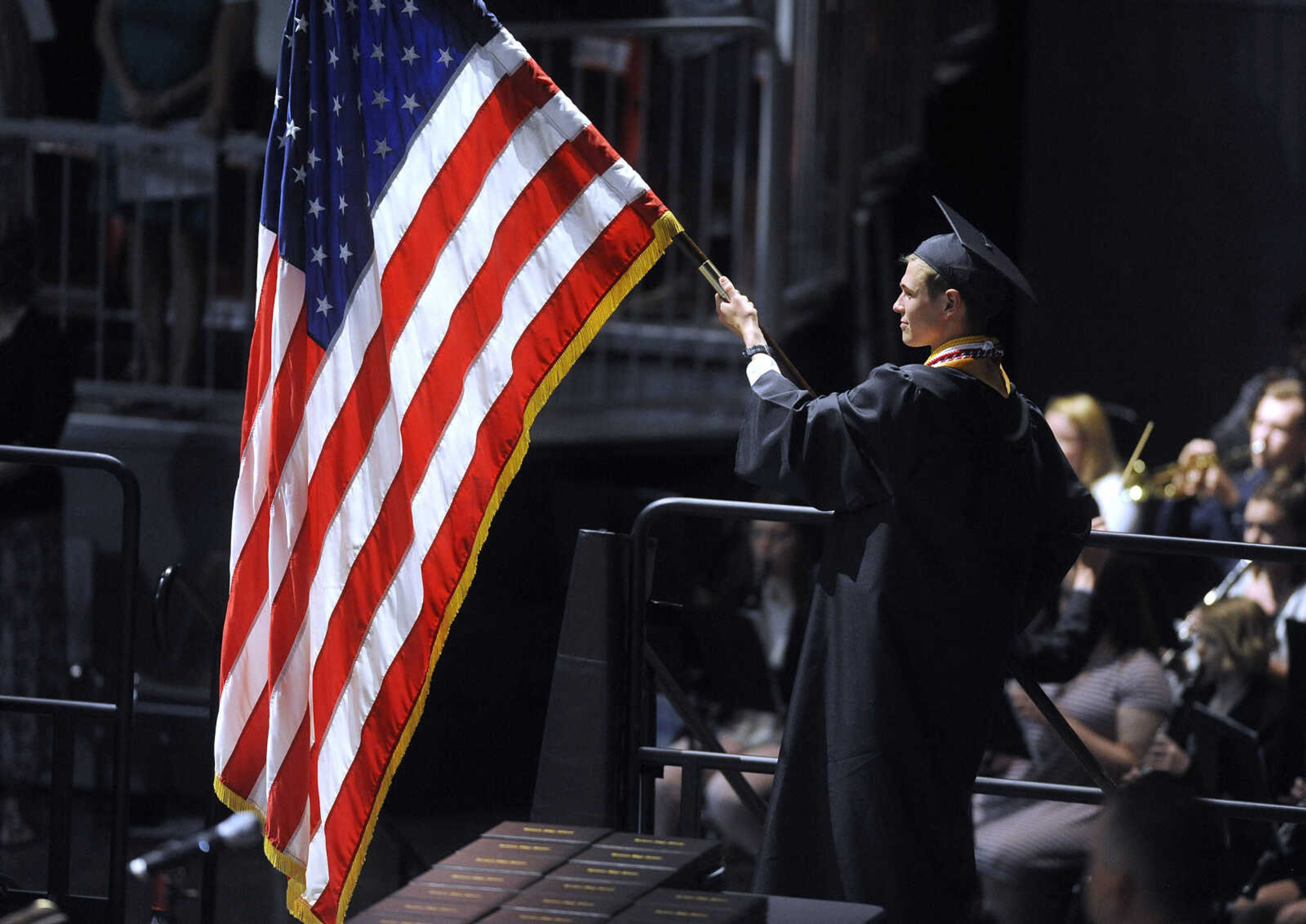 FRED LYNCH ~ flynch@semissourian.com
Ean Buffington, student body president, holds the flag during the processional for the Jackson High School commencement Friday, May 18, 2018 at the Show Me Center.