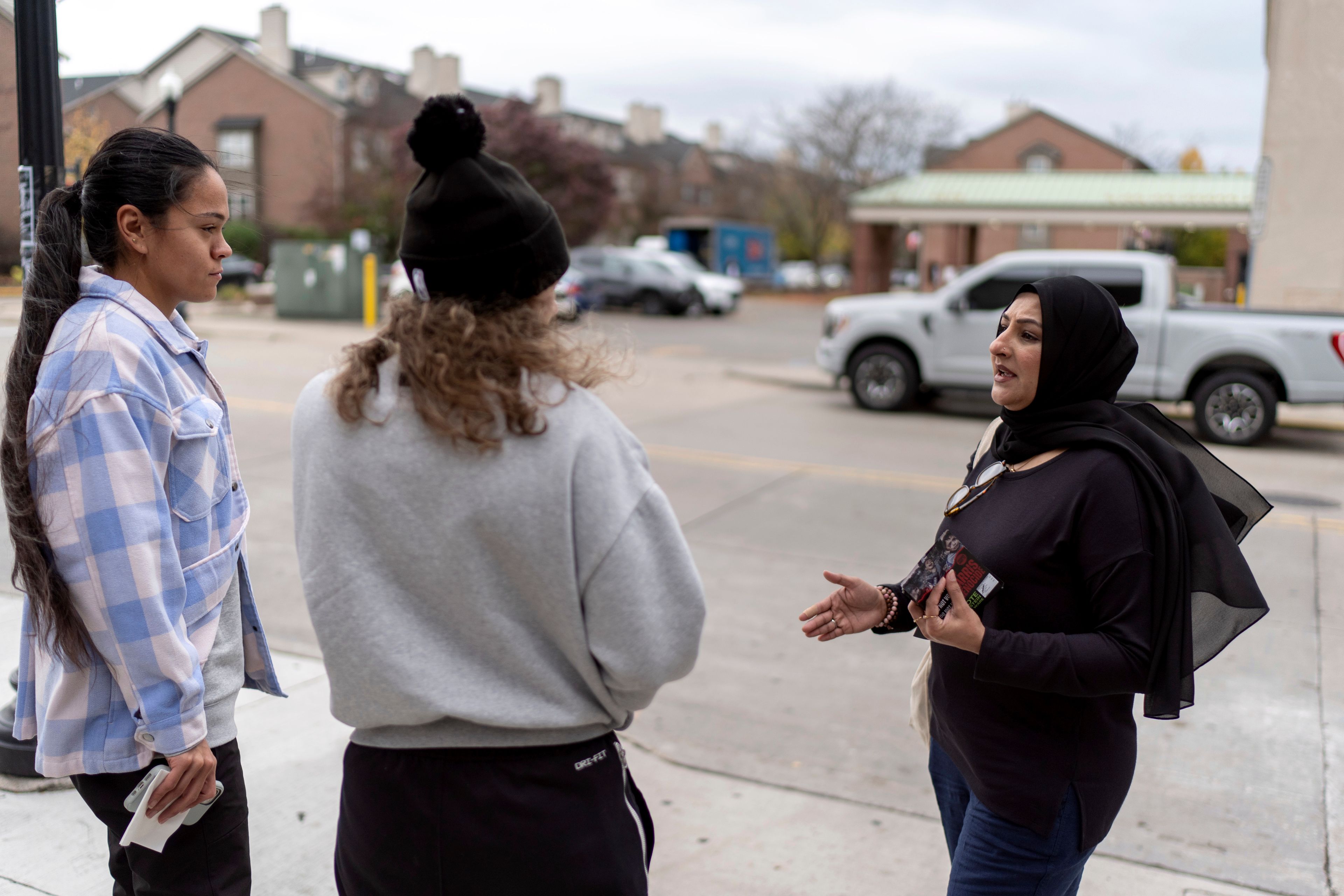 Farah Khan, right, co-chair of the Abandon Harris Michigan campaign, tries to convince pedestrians to vote for Green Party presidential candidate Jill Stein, Monday, Nov. 4, 2024, in Dearborn, Mich., the nation's largest Arab-majority city. (AP Photo/David Goldman)