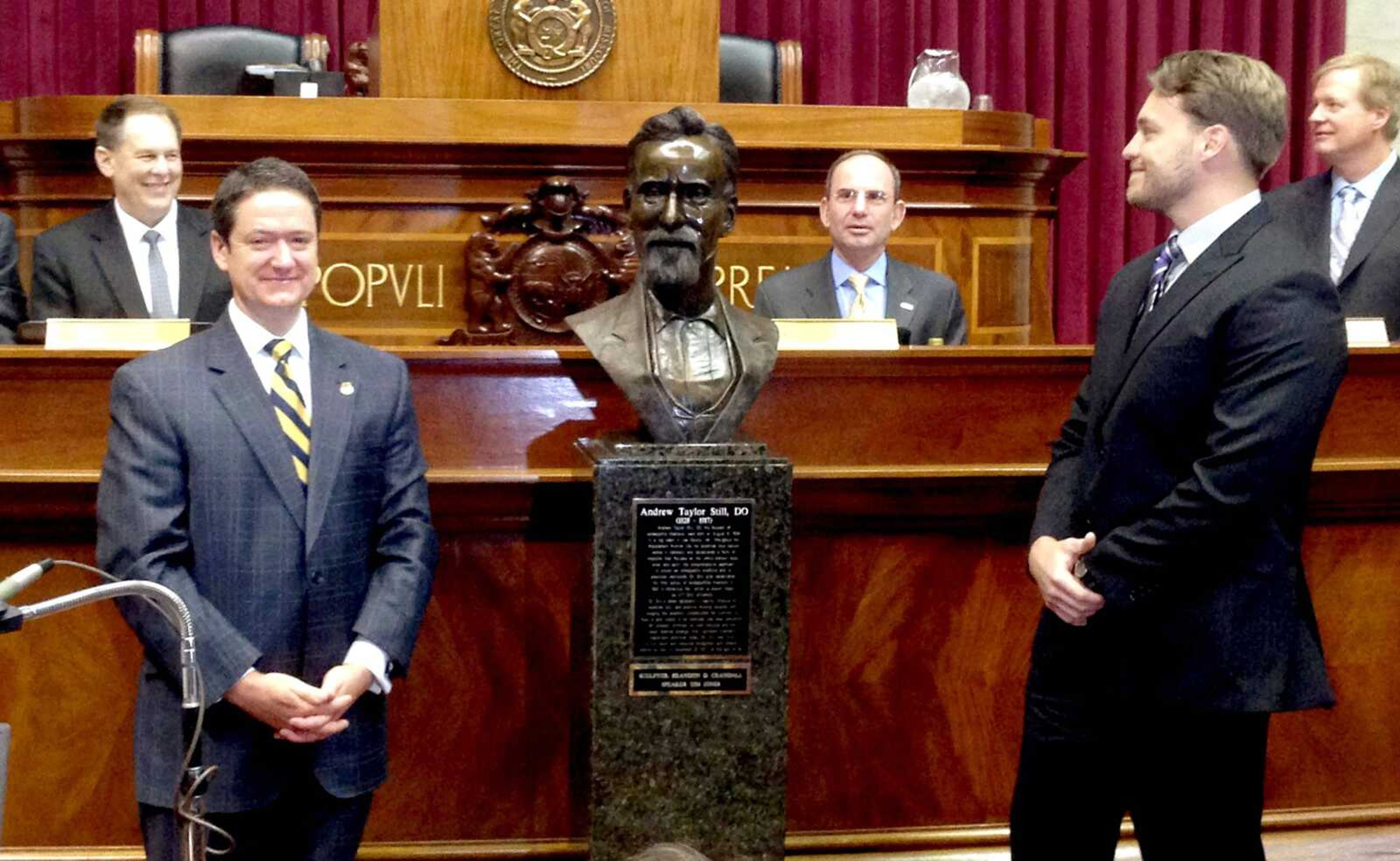 Missouri House Speaker Tim Jones and sculptor Brandon Crandall unveil a bronze bust of physician Andrew Taylor Still during a ceremony Wednesday, April 16, 2014 at the state Capitol in Jefferson City, Mo. Still is regarded as the father of osteopathic medicine and was inducted into the Hall of Famous Missourians. (AP Photo/Chris Blank)