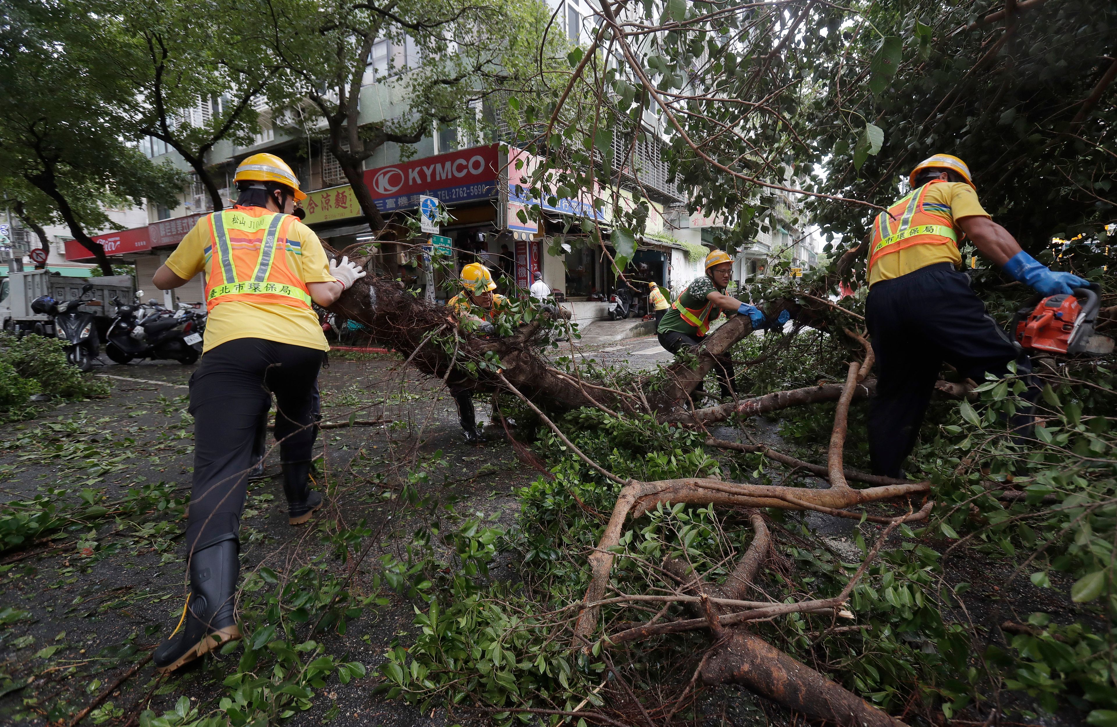 Sanitation workers of Taipei city government clear debris in the aftermath of Typhoon Kong-rey in Taipei, Taiwan, Friday, Nov. 1, 2024. (AP Photo/Chiang Ying-ying)