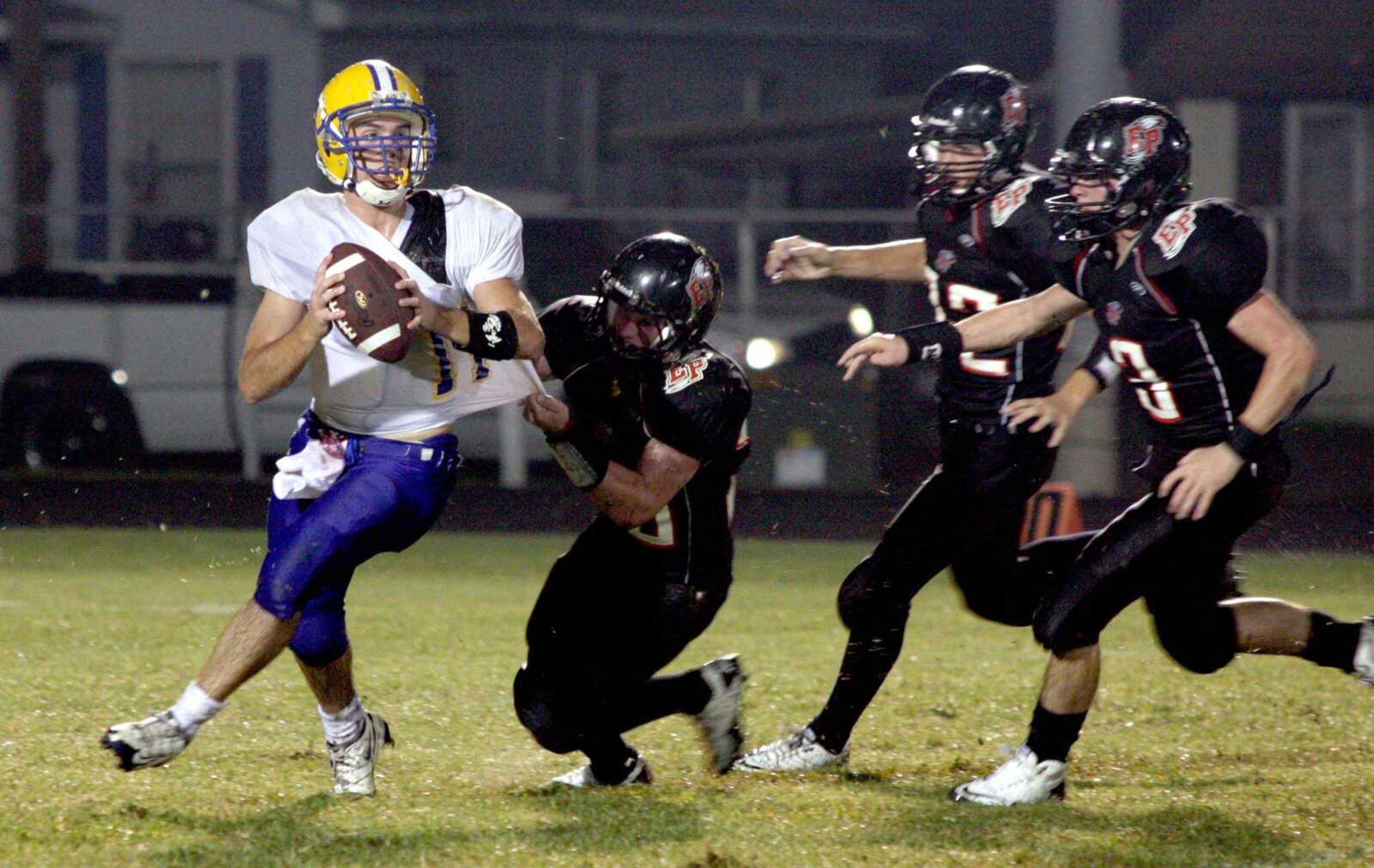 Scott City quarterback Jamie Scholz looks to pass as East Prairie defender Aaron Miller tries to bring him down during the fourth quarter Friday in East Prairie, Mo. (CHRIS POBST ~ Sikeston Standard Democrat)