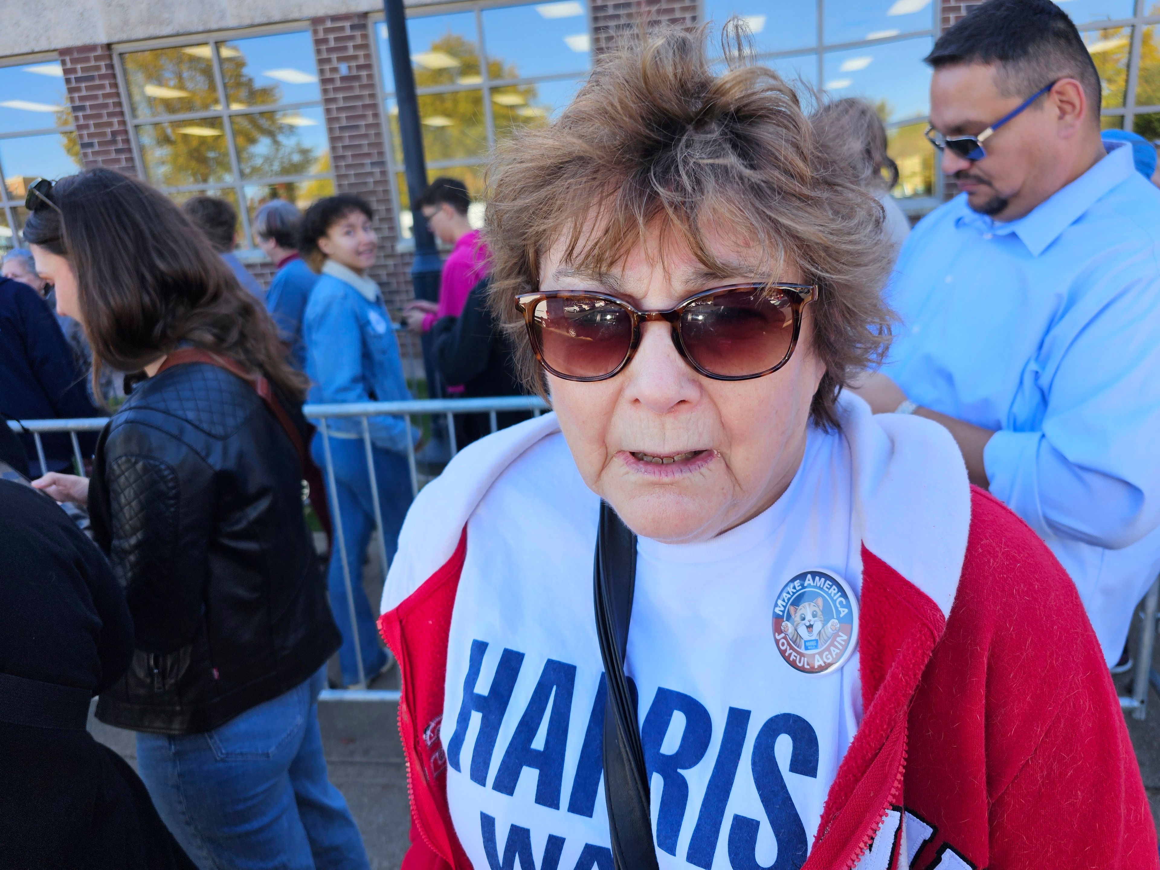 Joy Olson, of La Crosse, Wis., wearing a pin saying "Make America Joyful Again," speaks before a campaign event for Democratic presidential nominee Vice President Kamala Harris, Thursday, Oct. 17, 2024, at the University of Wisconsin La Crosse. (AP Photo/Steve Karnowski)