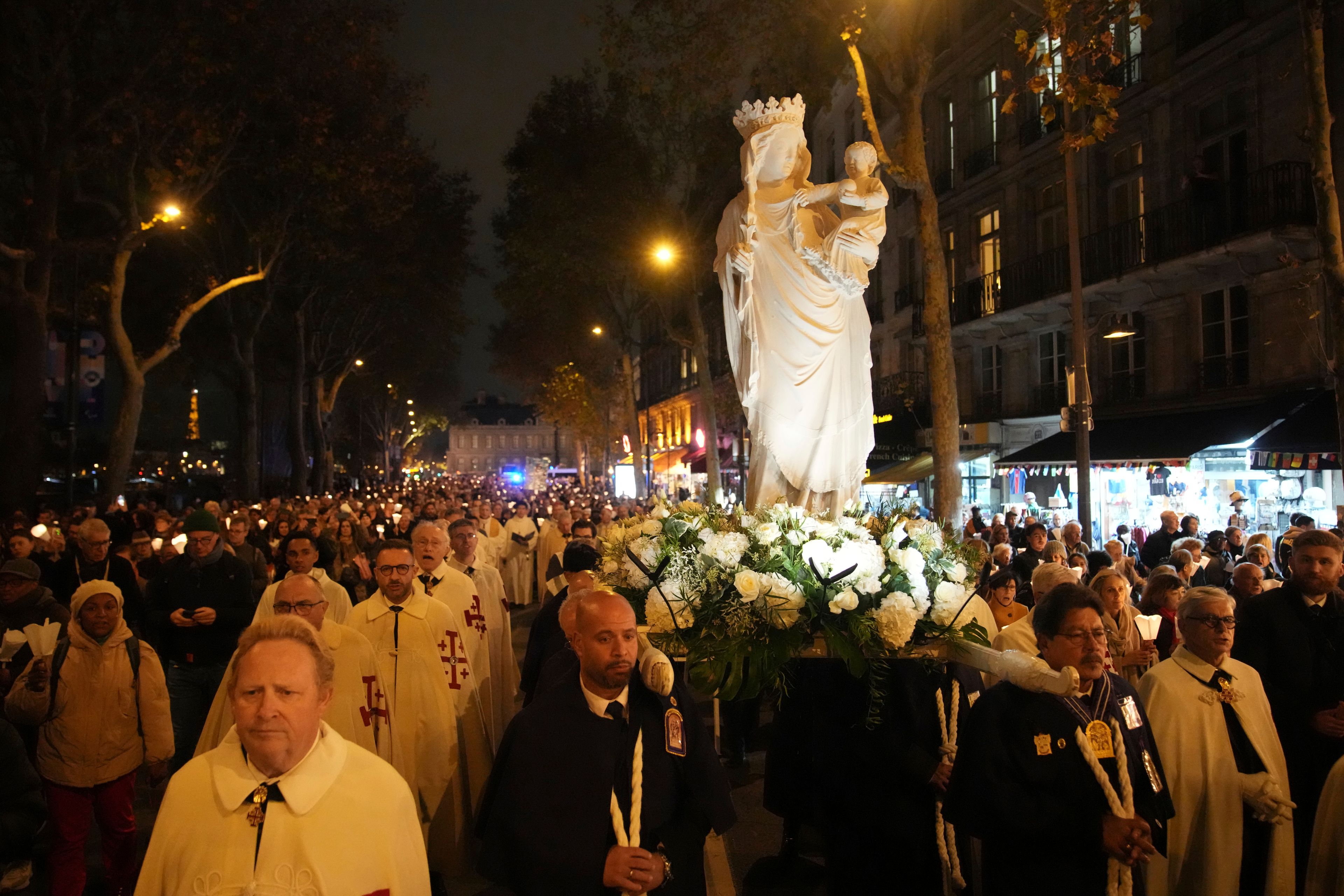 A replica of the Virgin Mary statue is carried from Saint-Germain l'Auxerrois church to Notre-Dame cathedral during a procession, Friday, Nov. 15, 2024 in Paris. (AP Photo/Christophe Ena)