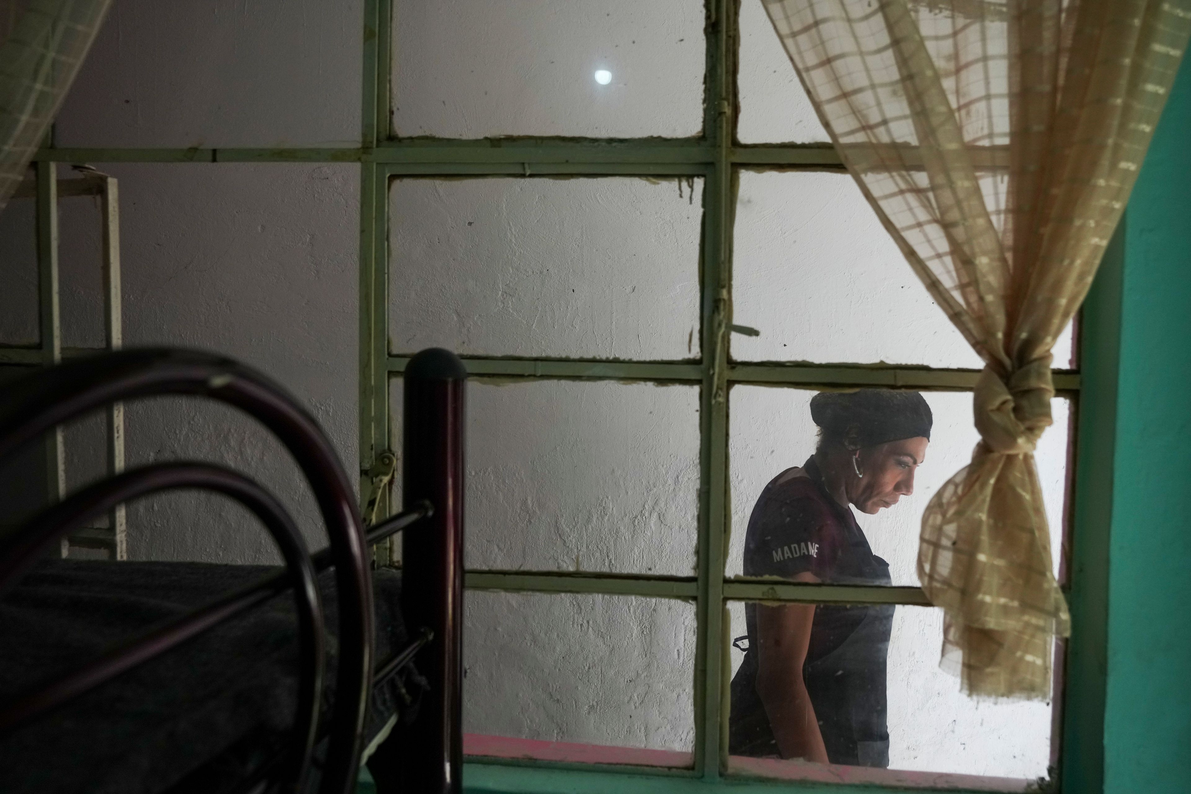 Karolina Long Tain González Rodríguez, a trans woman, walks past a kitchen in Casa Lleca, an LGBTQ+ shelter located in the Peralvillo neighborhood of Mexico City, Friday, Sept. 20, 2024. (AP Photo/Fernando Llano)