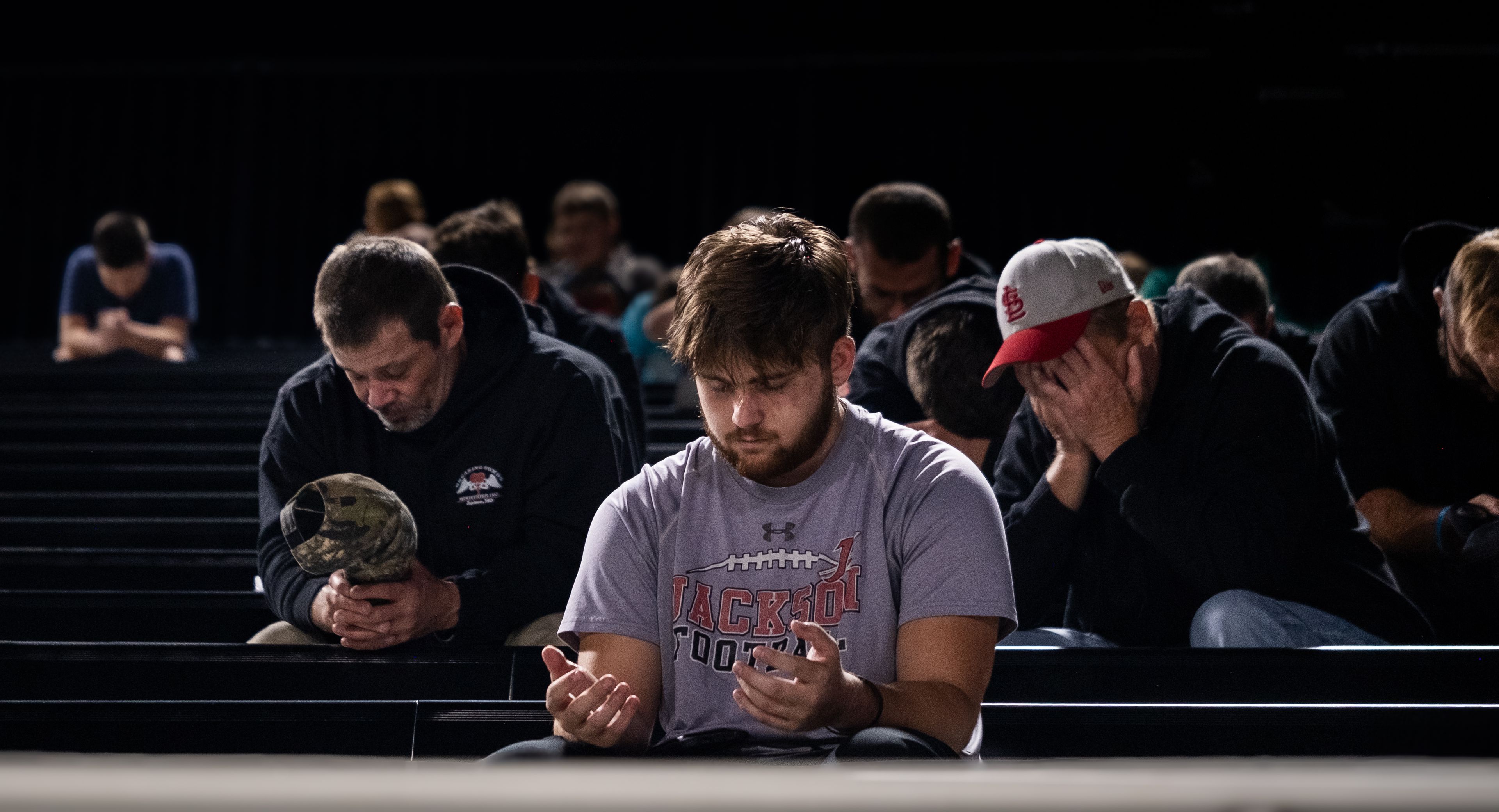 United in faith, community members of all walks of life bow their heads in a moment of prayer at the Fellowship of Christian Athletes Fields of Faith event Wednesday, Oct. 9, at Houck Stadium.