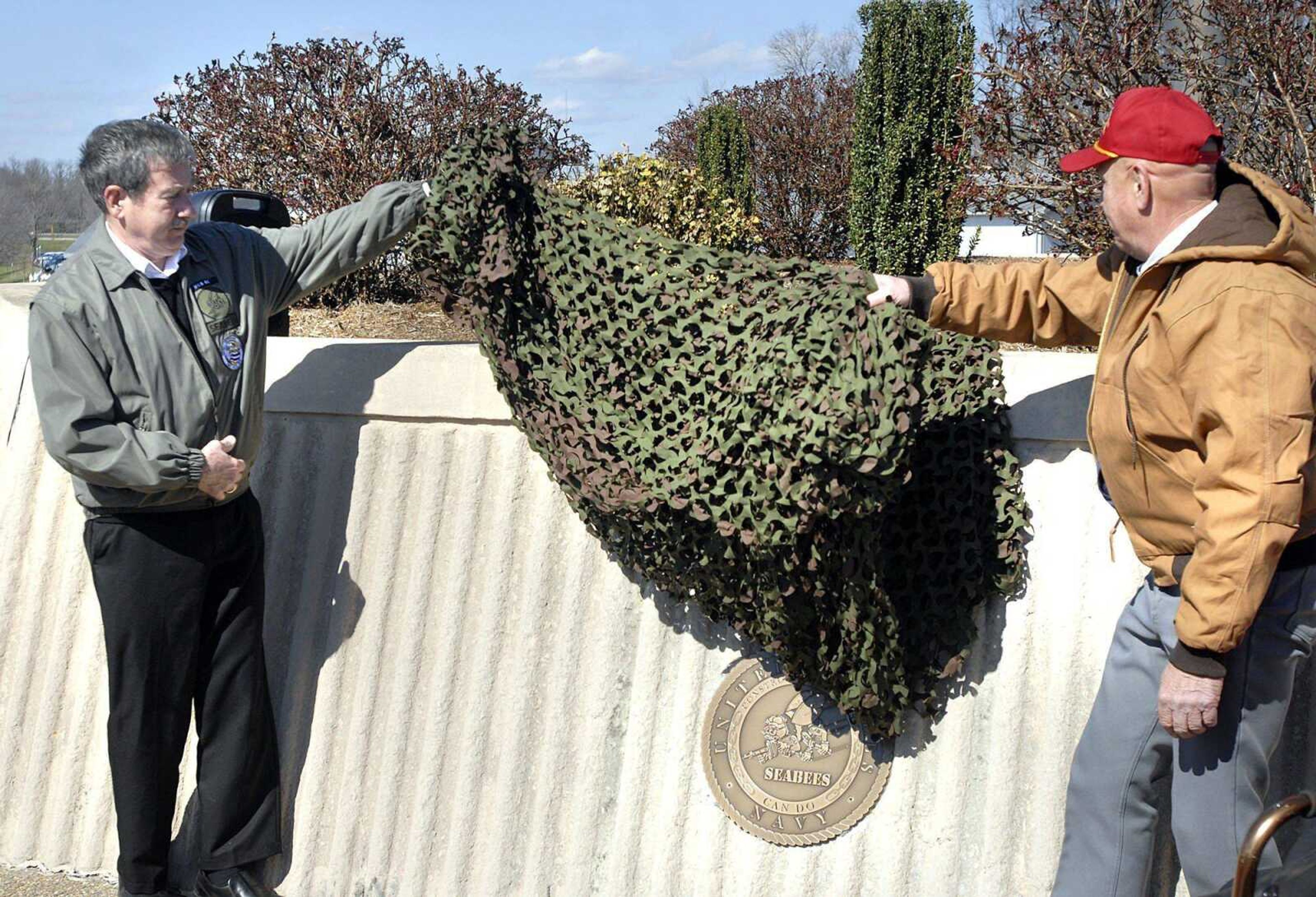 Tom Meyer and Seabees Chapter Island 5 Commander Larry Henderschott unveil the Seabees plaque Saturday at the base of the Veterans Memorial in Cape County Park. The plaque honors the small Naval unit's 70th anniversary. (Patrick T. Sullivan)