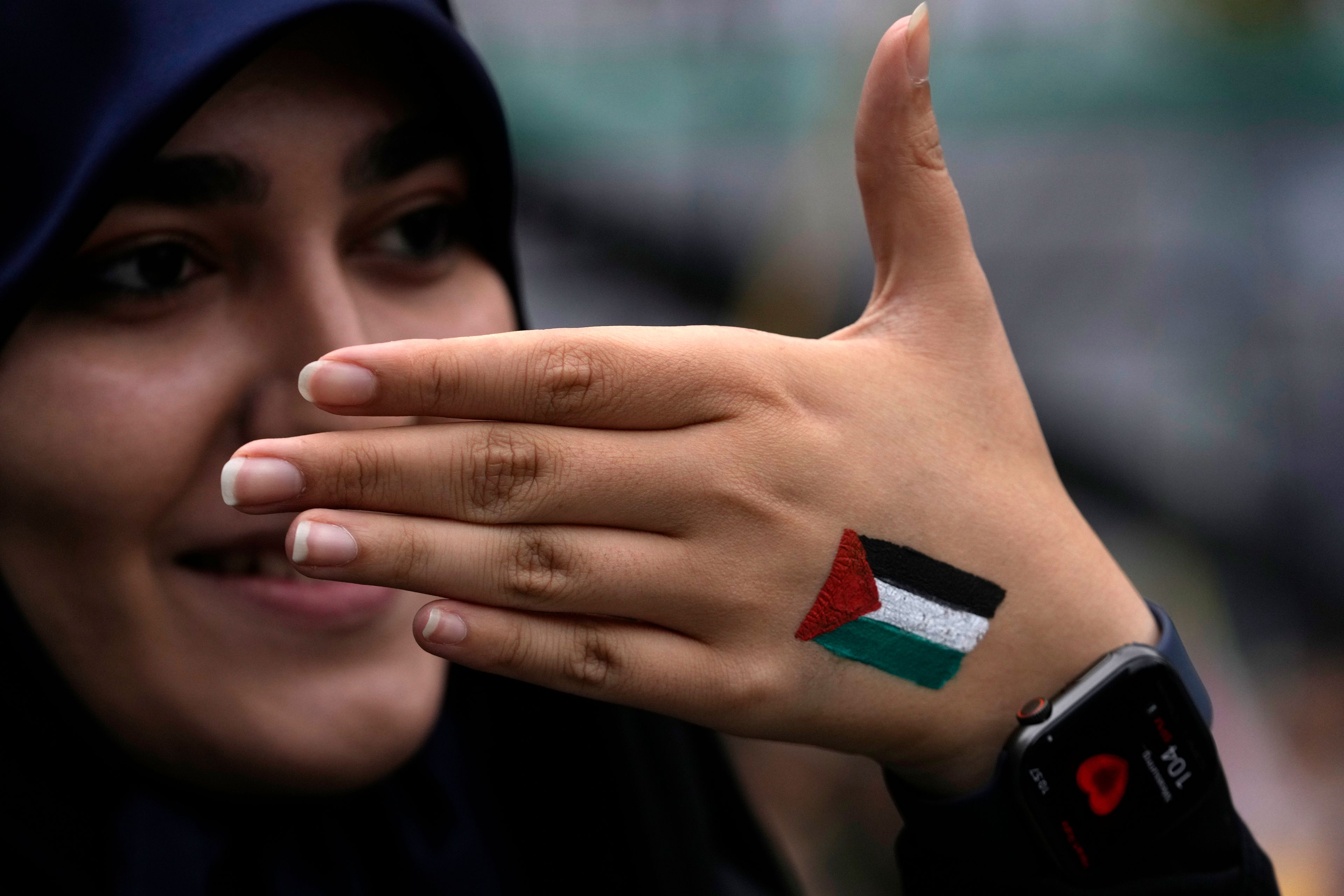 A woman shows her hand painted with the Palestinian flag in an annual rally in front of the former U.S. Embassy in Tehran, Iran, Sunday, Nov. 3, 2024, marking the 45th anniversary of Iranian students' takeover of the embassy, starting a hostage crisis. (AP Photo/Vahid Salemi)