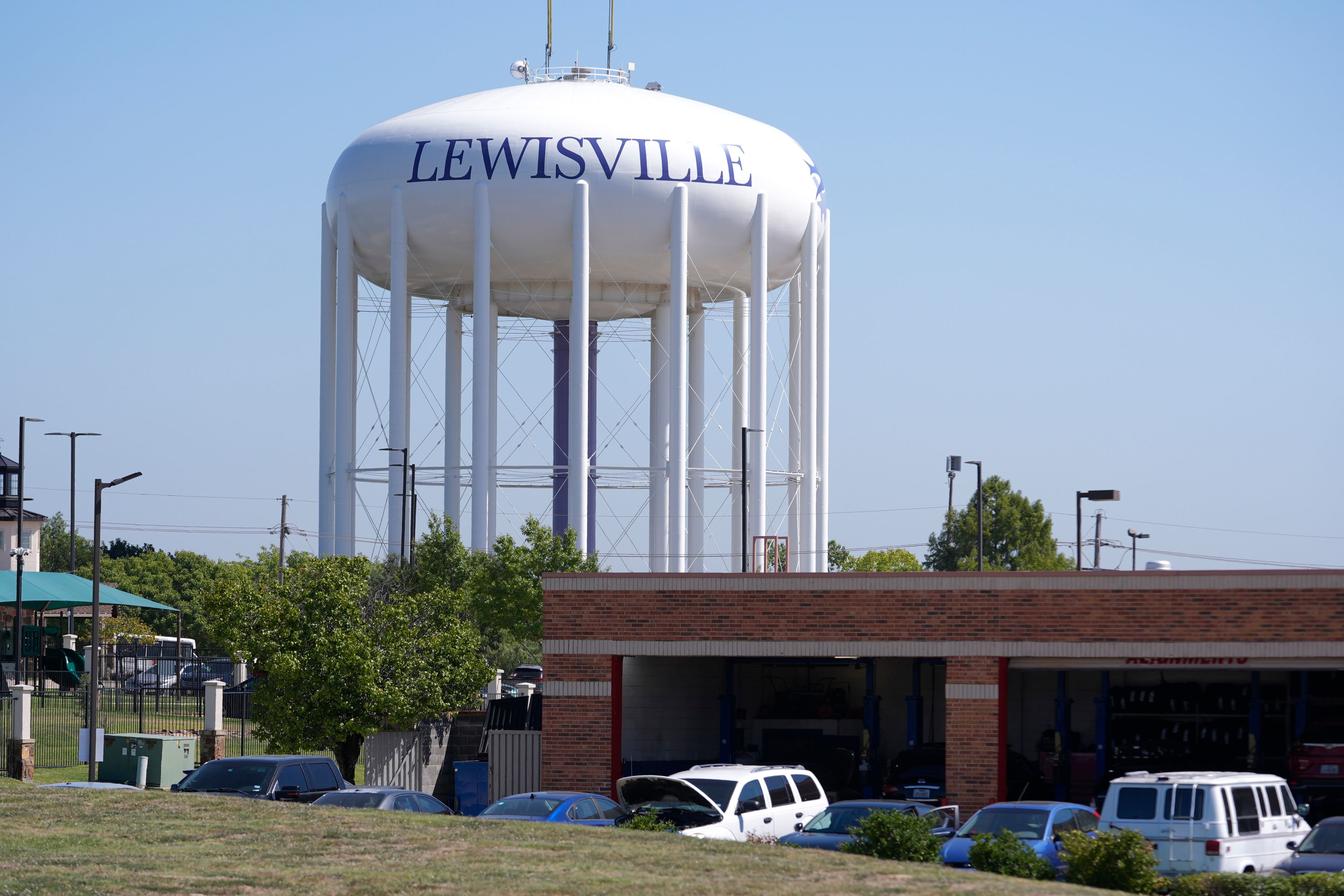 A water tower sits near businesses in Lewisville, Texas, Wednesday, Oct. 2, 2024. (AP Photo/LM Otero)