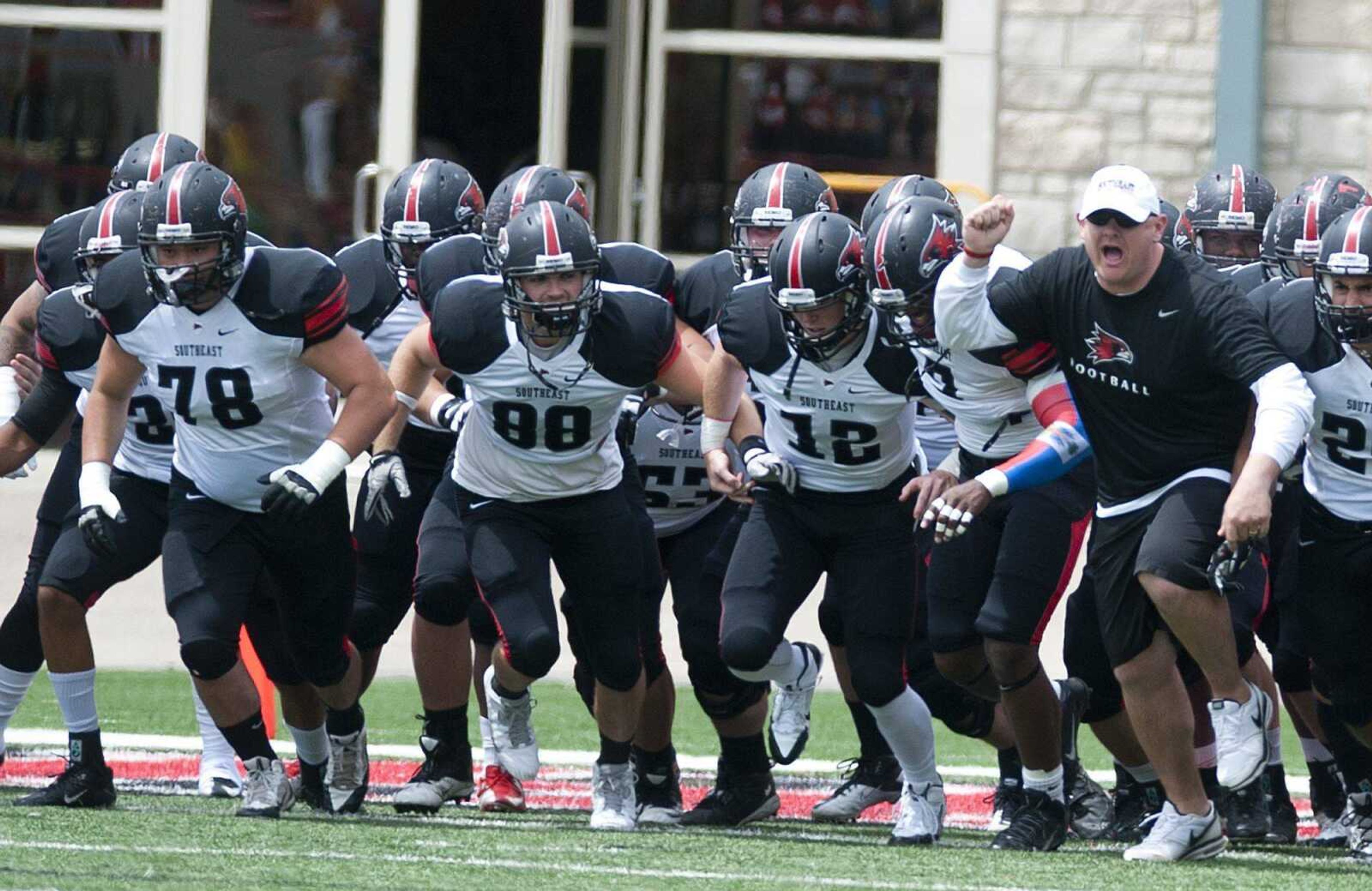 Southeast Missouri State offensive coordinator Sherard Poteete, right, leads the White Team onto the field for the 2014 Spring Game last April at Houck Stadium. The Redhawks begin their 2014 campaign today against Missouri Baptist. (Southeast Missourian file)