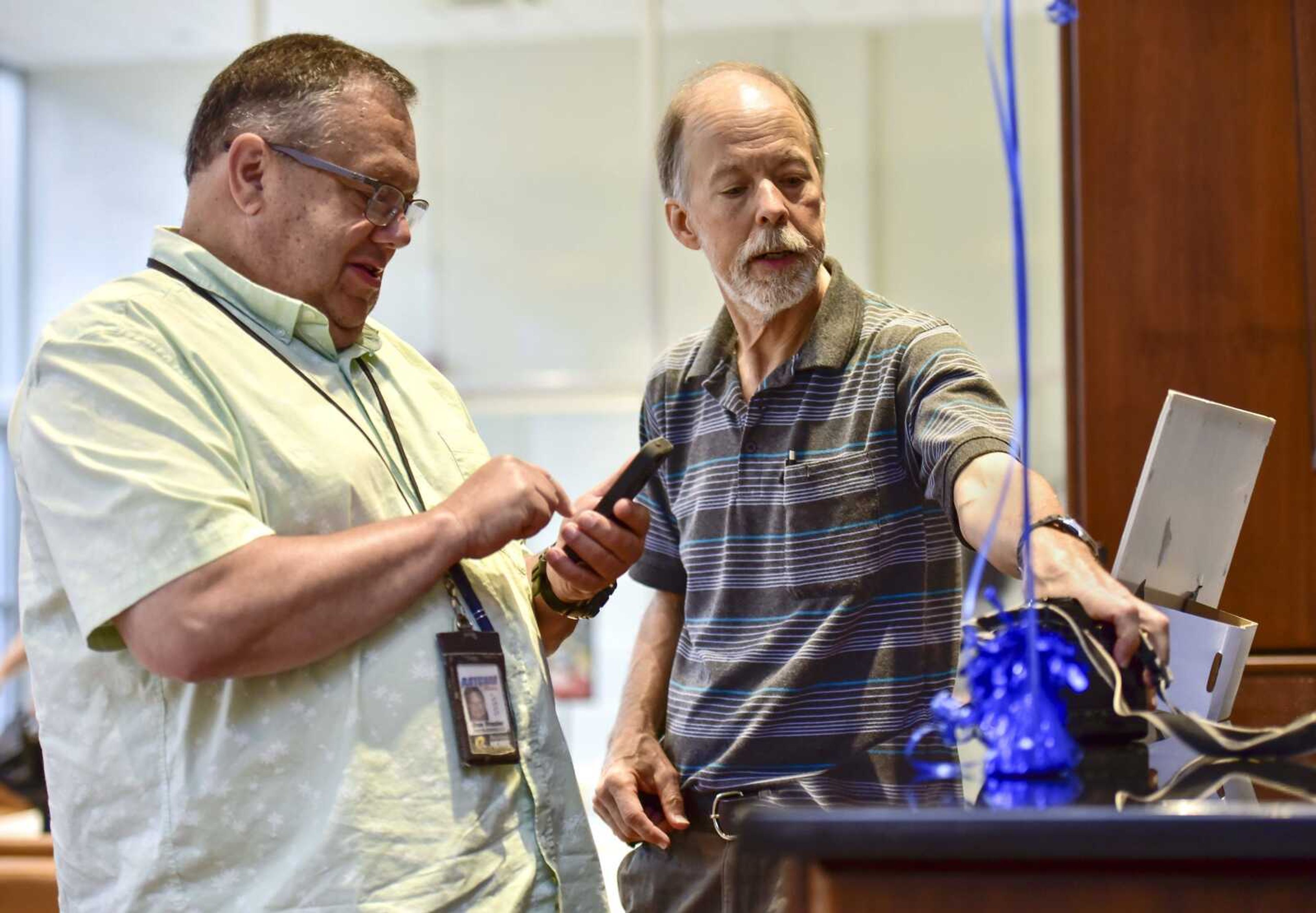 Southeast Missourian photojournalist Fred Lynch, center right, and KFVS12's Don Frazier reminisce over a Canon T90 SLR camera Friday, Aug. 24, 2018 in the Bullpen at the Rust Center for Media in Cape Girardeau. Lynch retired Friday after spending 43 years as a photojournalist for the Southeast Missourian.