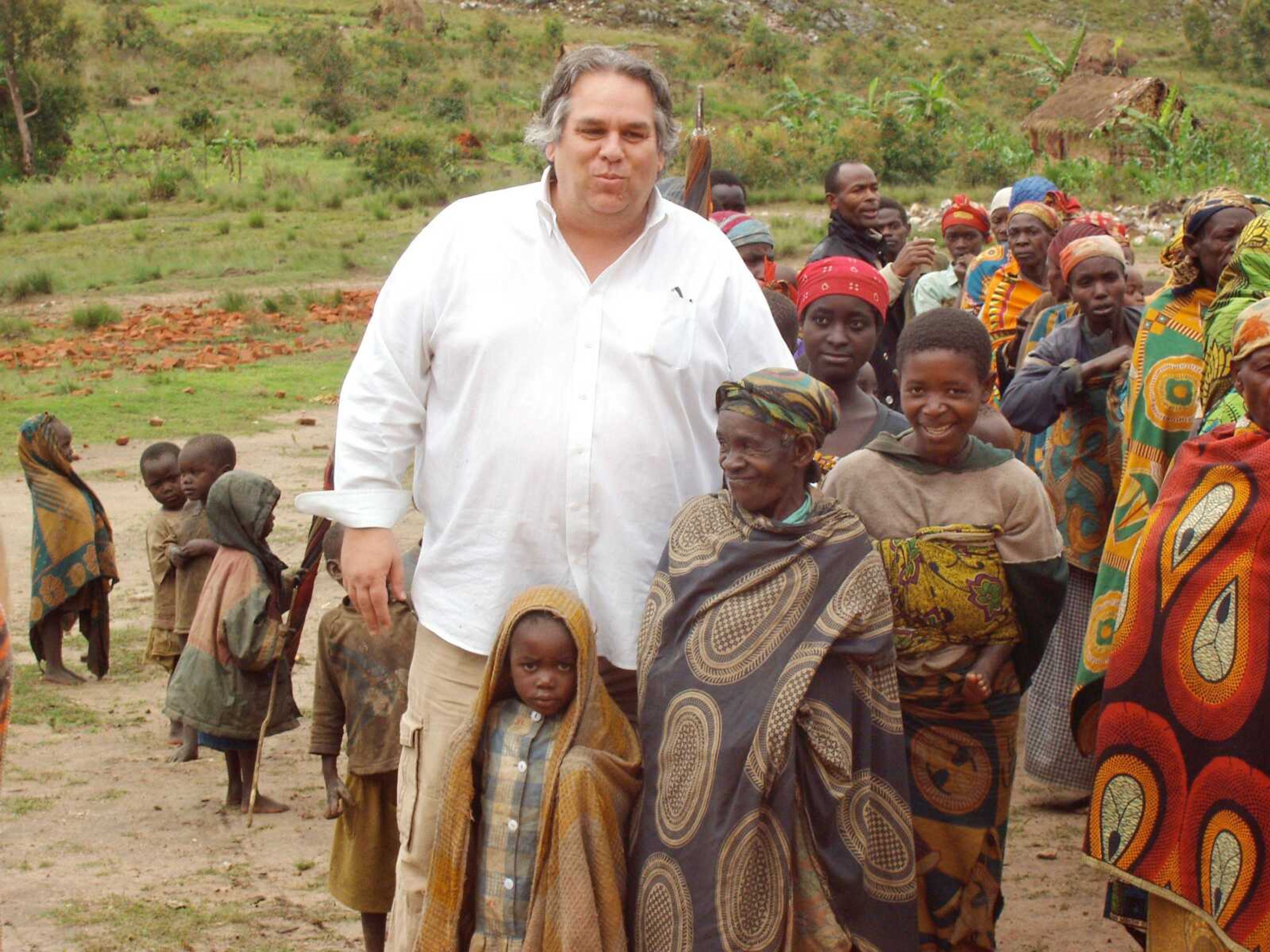 In this December 2007 photo obtained by The Associated Press, the Rev. Carl Keyes stands for a photo with impoverished people of the Batwa Tribe in Burundi during a delivery of relief supplies to the area. Keyes accompanied an established aid group to look into program possibilities, and after this trip, he created Aid for the World. (Associated Press)