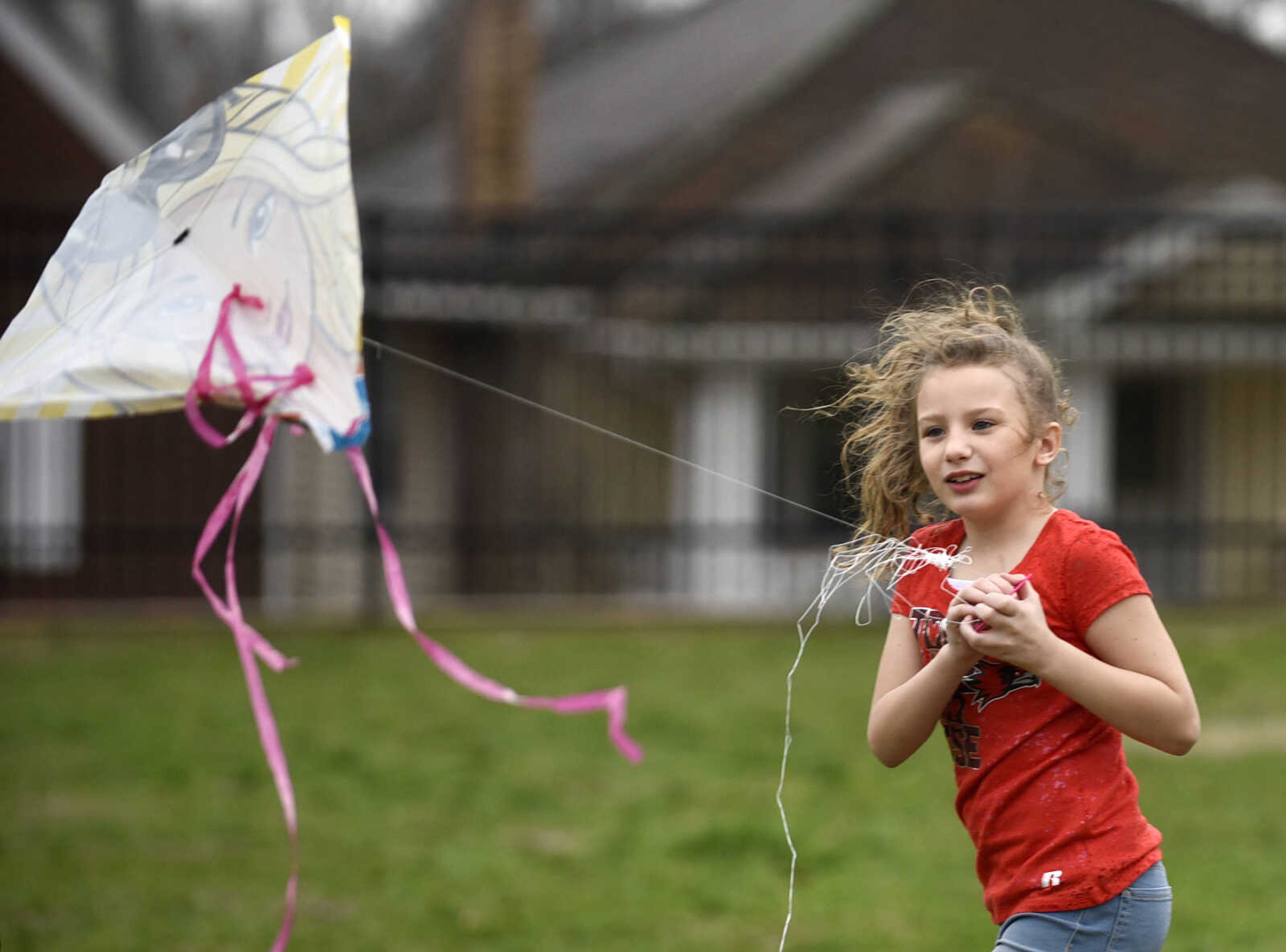 Abigail Coonts flies her kite on the playground on Friday, Feb. 24, 2017, at Franklin Elementary in Cape Girardeau. Lyndora Hughes second grade class spent a portion of the afternoon flying their kites as part of their story celebration after reading "Gloria Who Might Be My Best Friend".