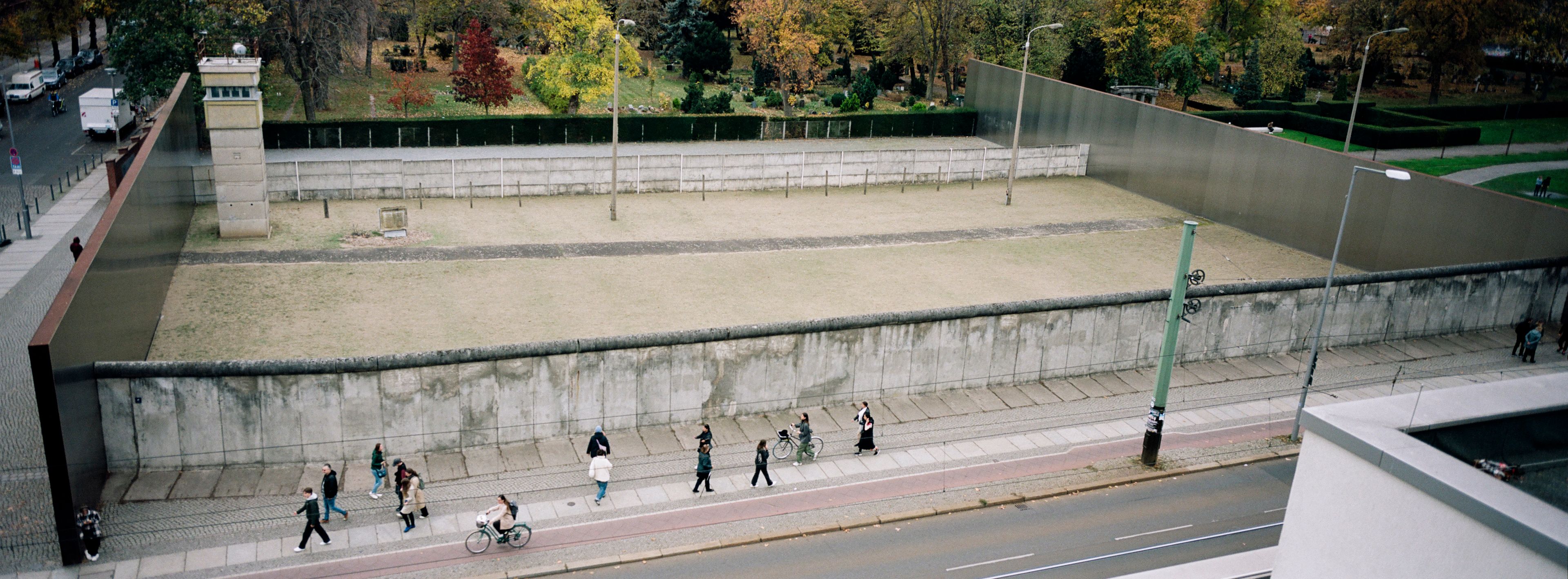 Visitors walk along remains of the Berlin Wall at the official Berlin Wall memorial site at Bernauer Strasse, in Berlin, Germany, Wednesday, Oct. 23, 2024. (AP Photo/Markus Schreiber)