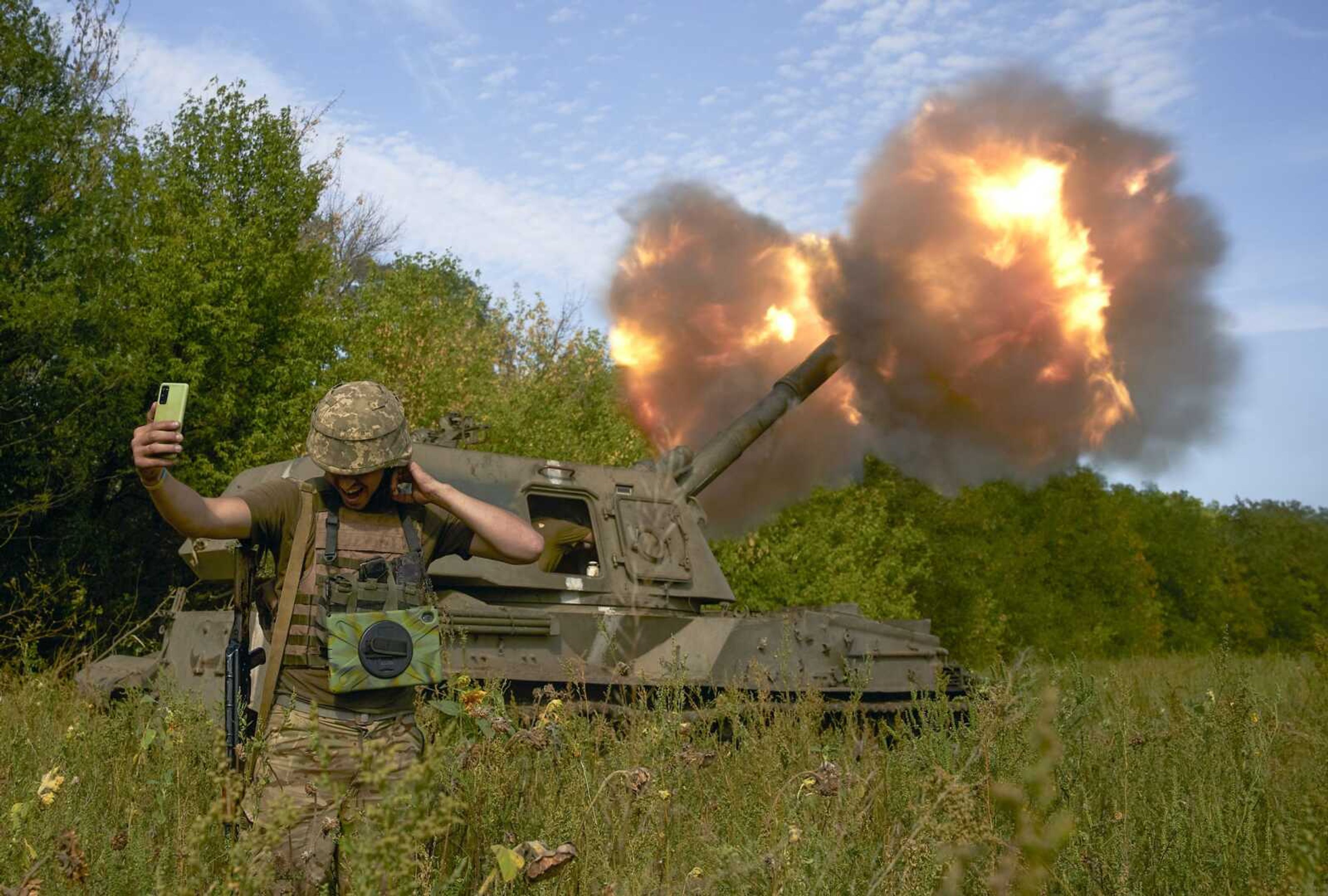 A Ukrainian soldier takes a selfie as an artillery system fires Saturday in the front line in Donetsk region, eastern Ukraine.