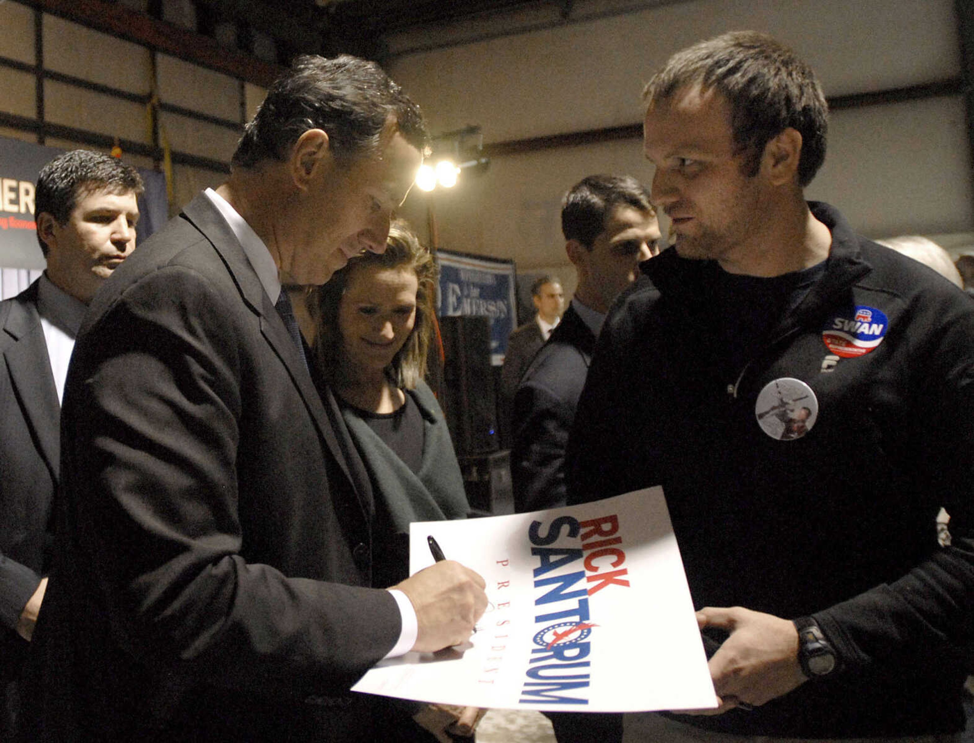 Republican presidential candidate Rick Santorum autographs a campaign sign during his campaign stop at the Cape Girardeau Regional Airport Saturday night, March 10, 2012. (Laura Simon)