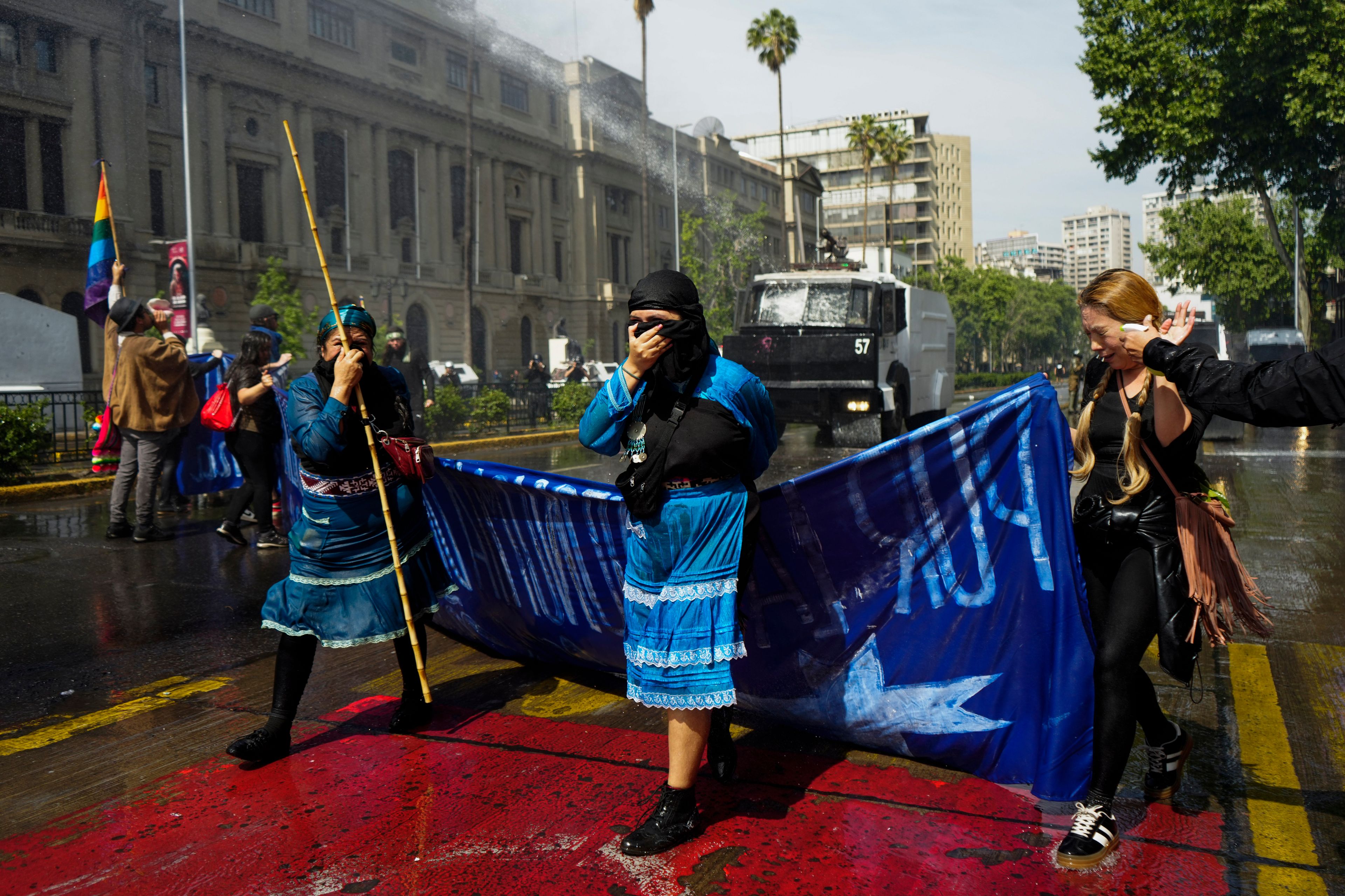 Police fire water and tear gas at Mapuche Indigenous women and supporters during a march to demand autonomous territory for Chile's Indigenous people and the release of pro-Mapuche detainees, in Santiago, Chile, Oct. 13, 2024. (AP Photo/Esteban Felix)